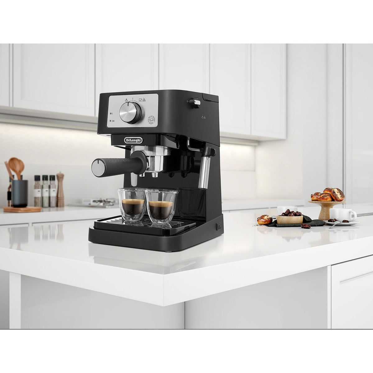 Black pump espresso machine on kitchen counter with two clear cups