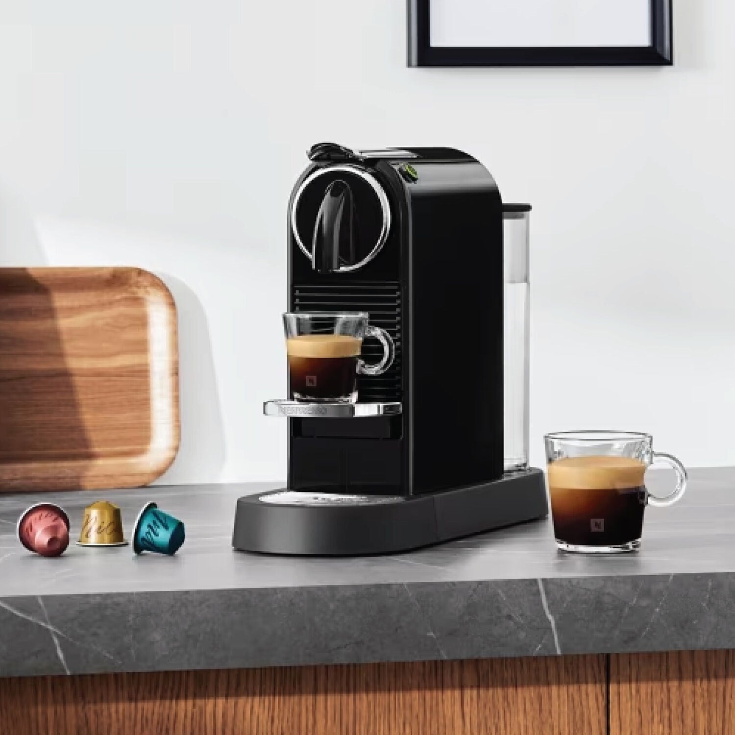 Black Nespresso Citiz espresso machine on countertop with a cup of espresso