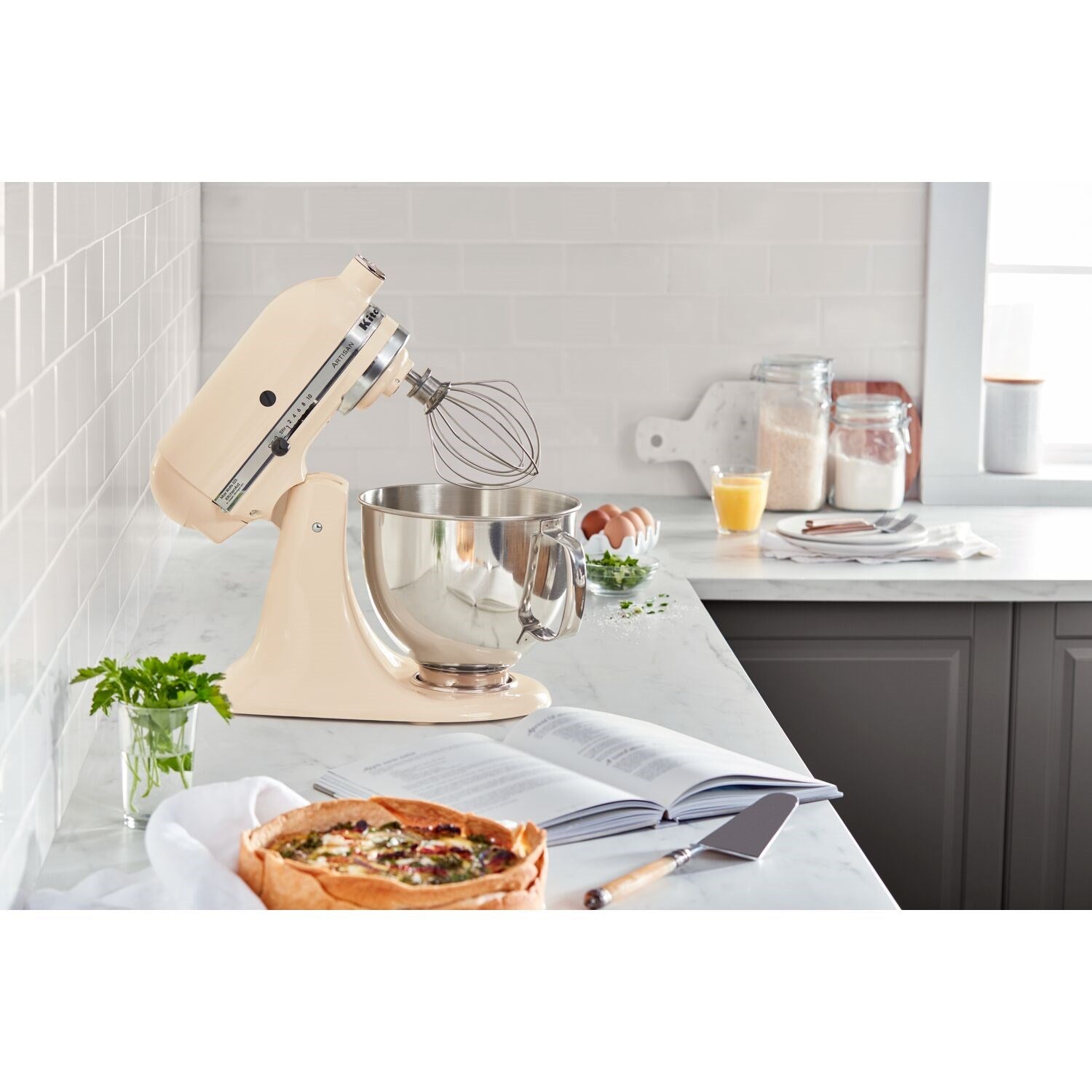 Almond cream tilt-head stand mixer with stainless bowl and wire whisk attachment