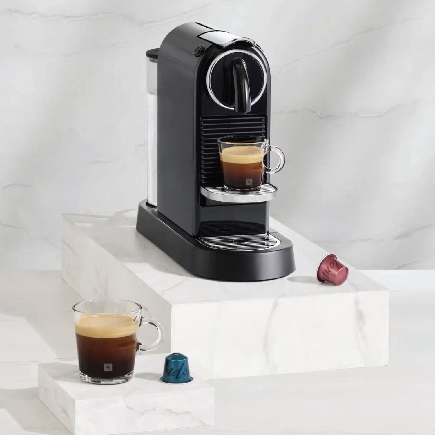 Black Nespresso Citiz espresso machine with frothing espresso cup and extra pods