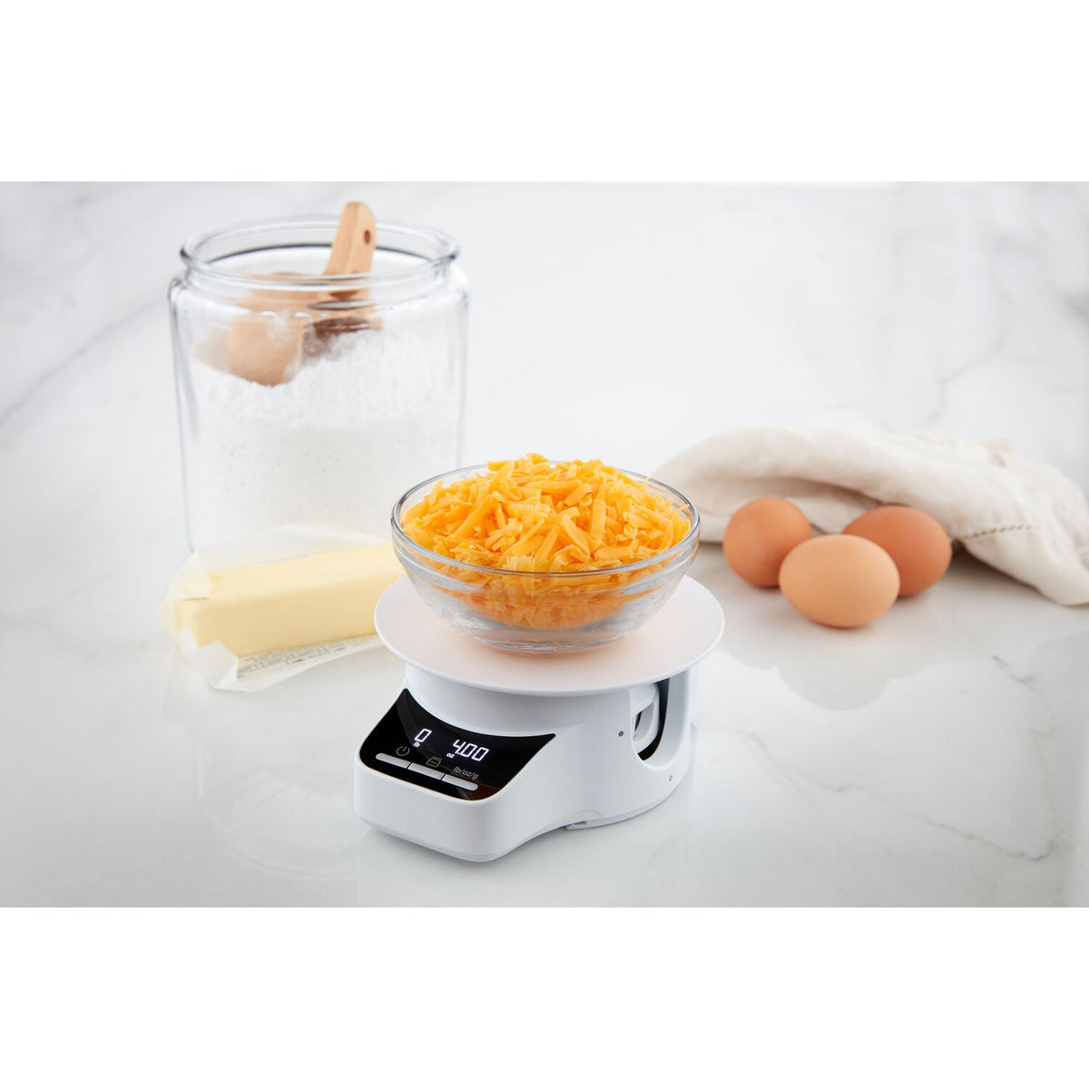 Digital sifter and scale base with display and clear bowl holding shredded ingredients