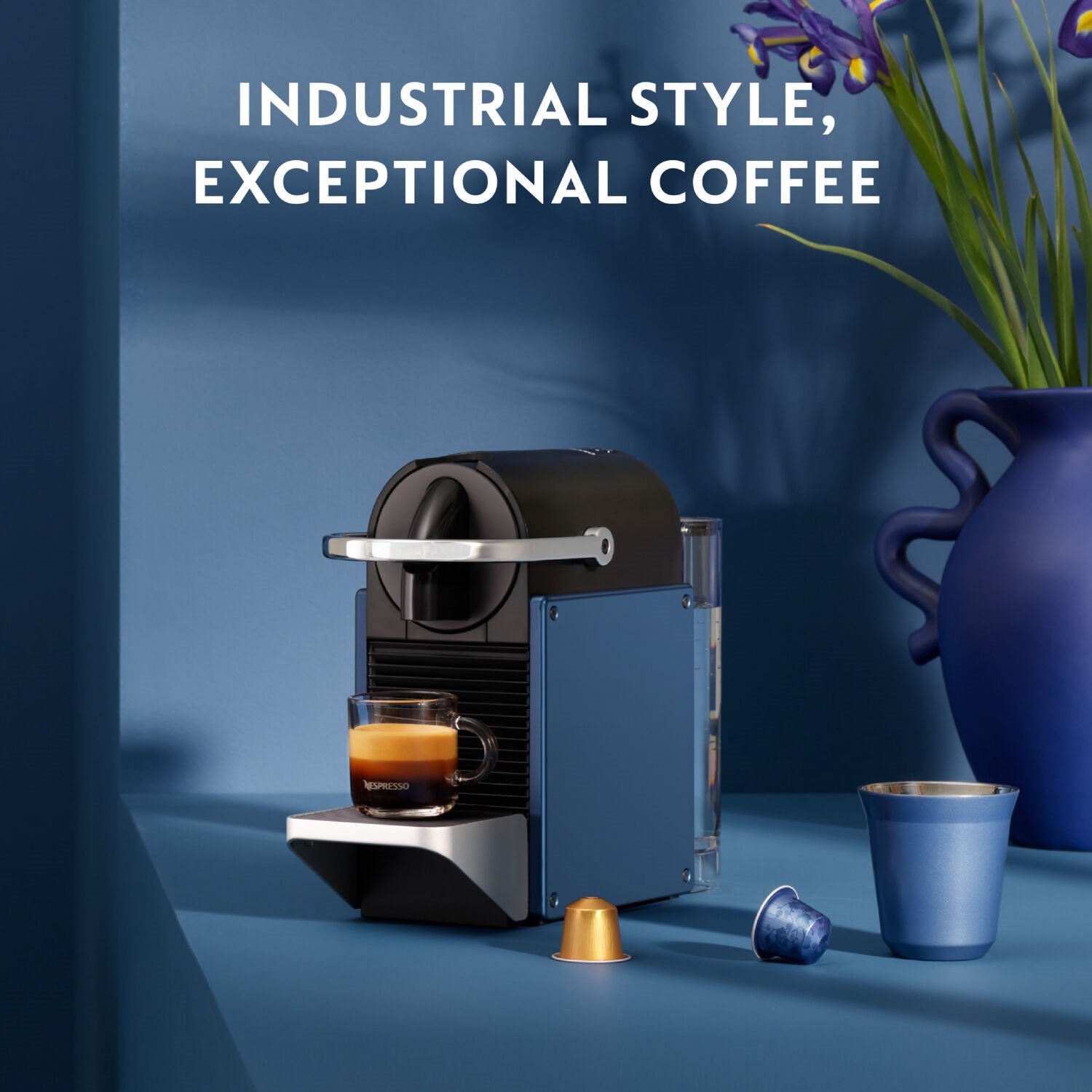 Nespresso Pixie espresso machine with dark blue body and cup on drip tray