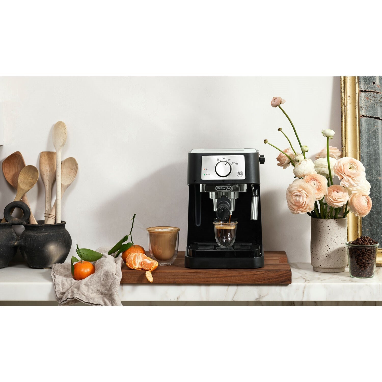 Black pump espresso machine on wooden surface with two coffee cups