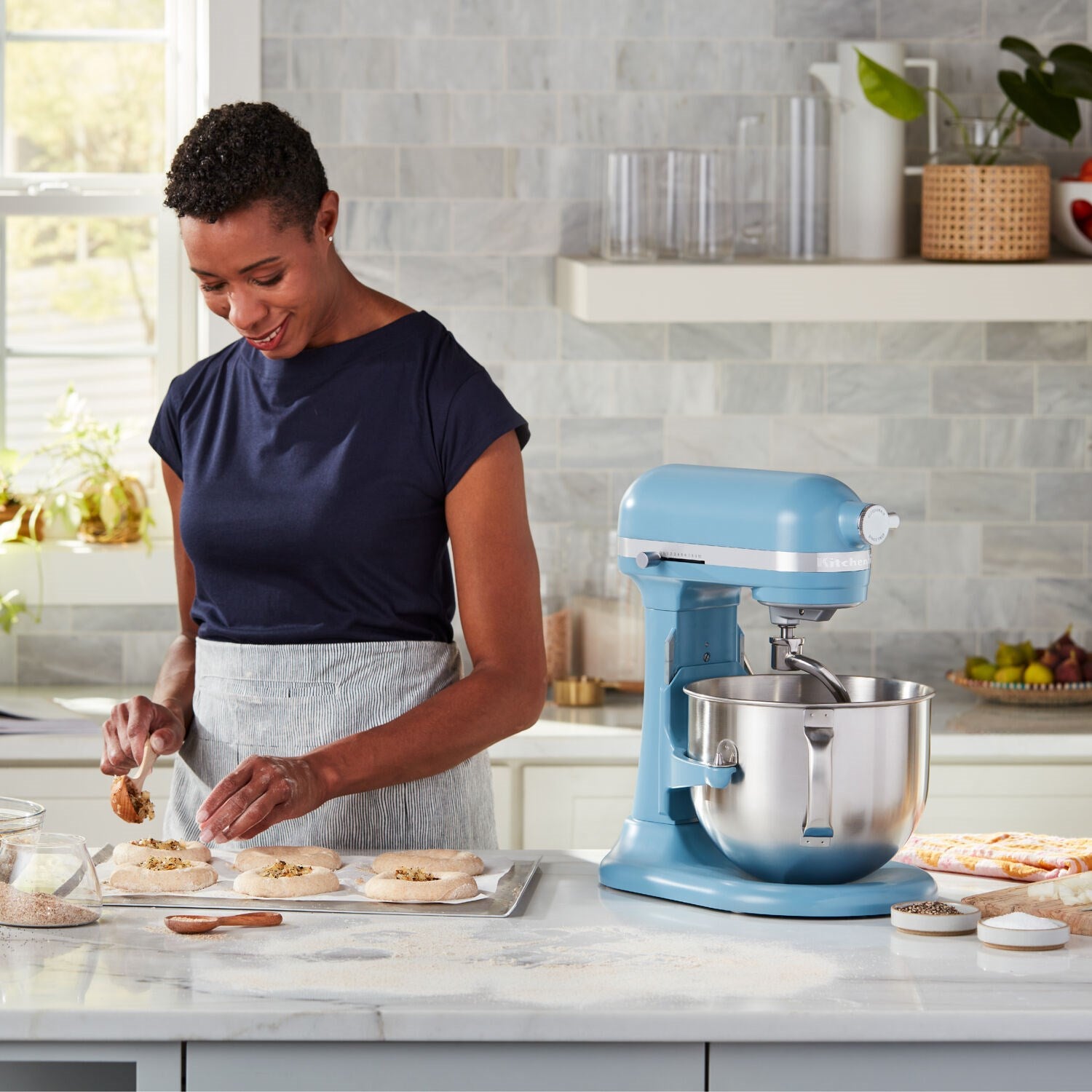 KitchenAid stand mixer in velvet blue with stainless bowl, mixing dough