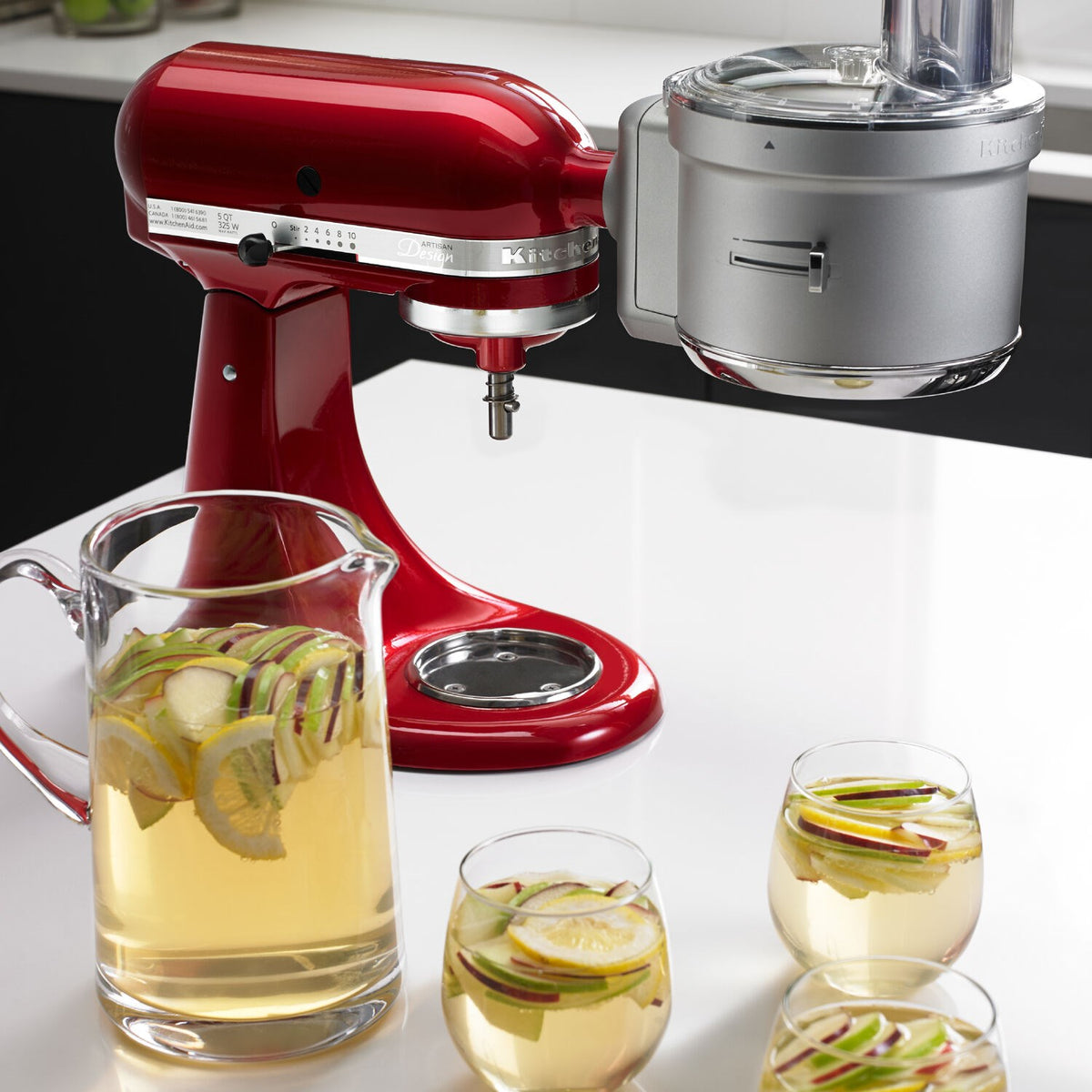 Red stand mixer with dicing attachment and serving glasses with sliced vegetables