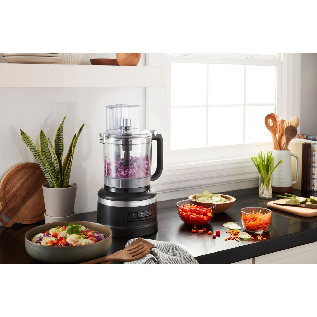 Black matte 13-cup food processor with clear work bowl on kitchen countertop