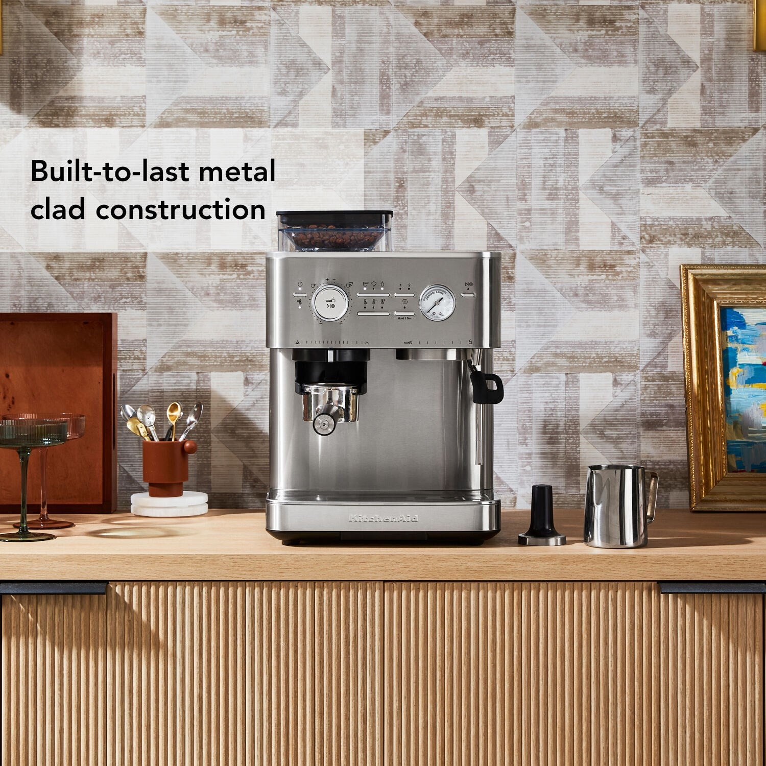 Stainless steel semi-automatic espresso machine on countertop with accessories