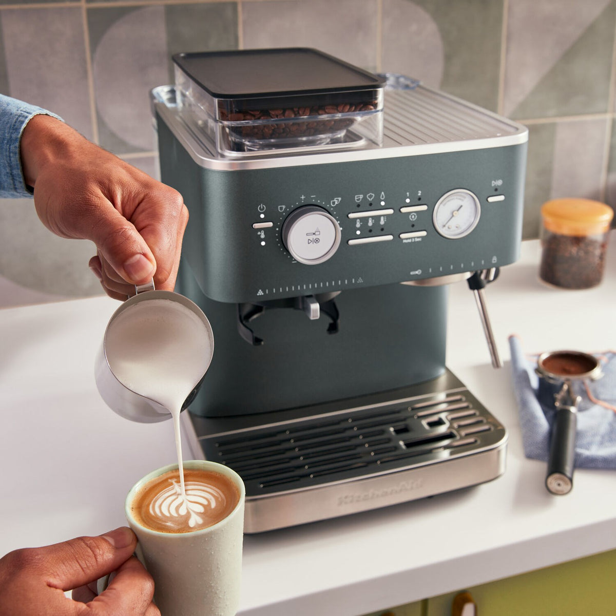 Juniper green espresso machine with hand pouring espresso into cup