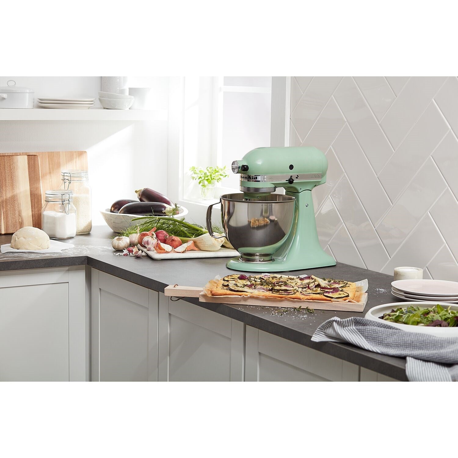 Pistachio tilt-head stand mixer with stainless bowl on kitchen counter