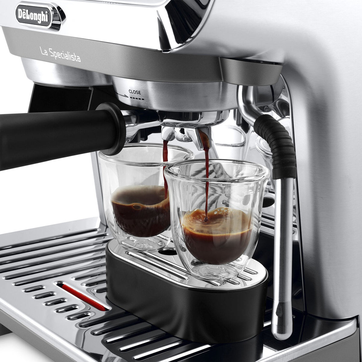 Silver espresso machine brewing group with two glasses beneath portafilter