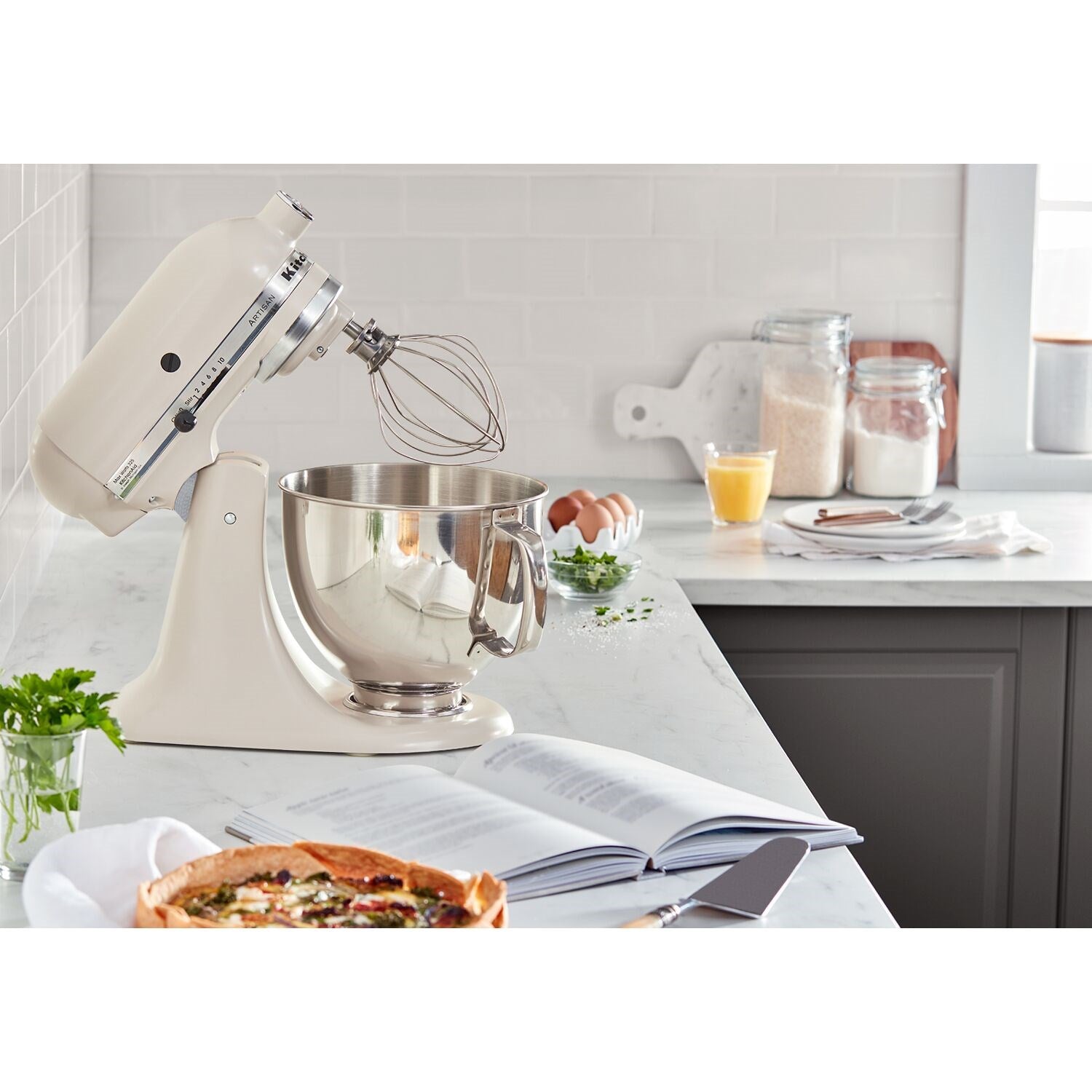 Milkshake-colored tilt-head stand mixer with stainless steel bowl and whisk attachment
