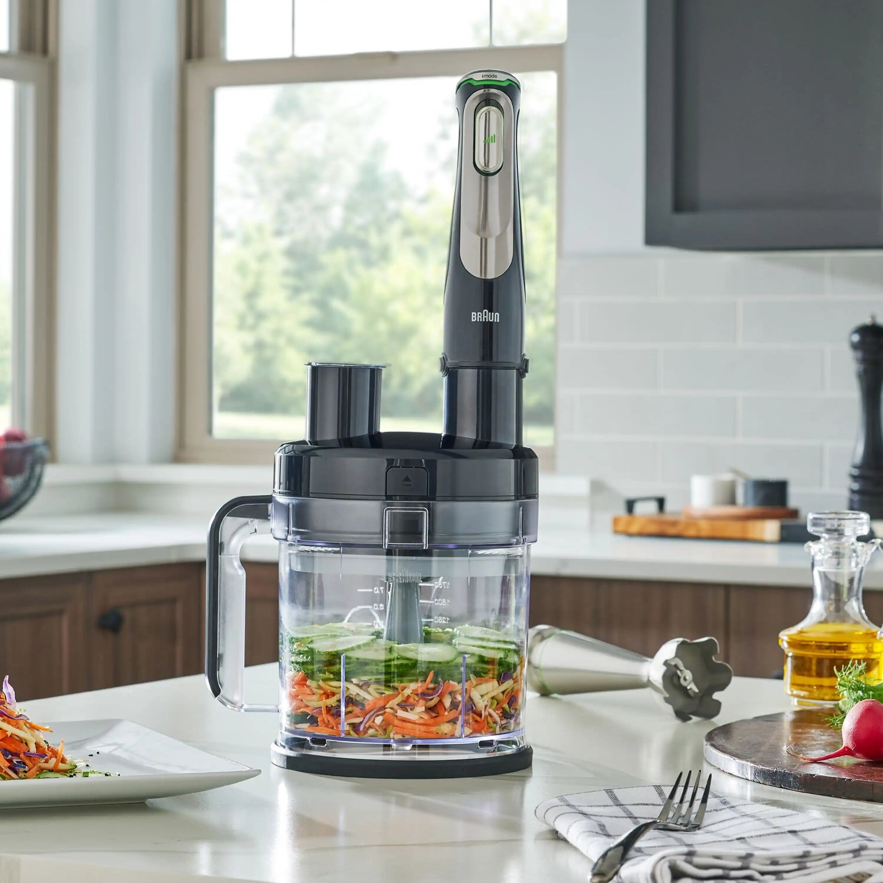 Braun SmartSpeed hand blender with clear chopper bowl and mixed vegetables on counter