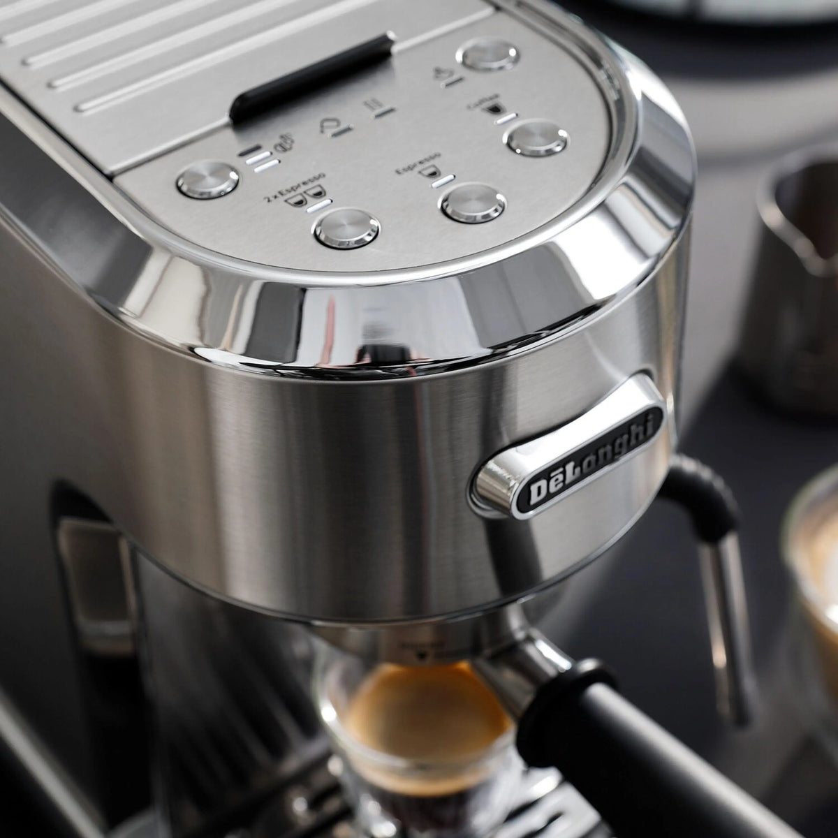 Stainless steel espresso machine control panel with De'Longhi logo and steam controls