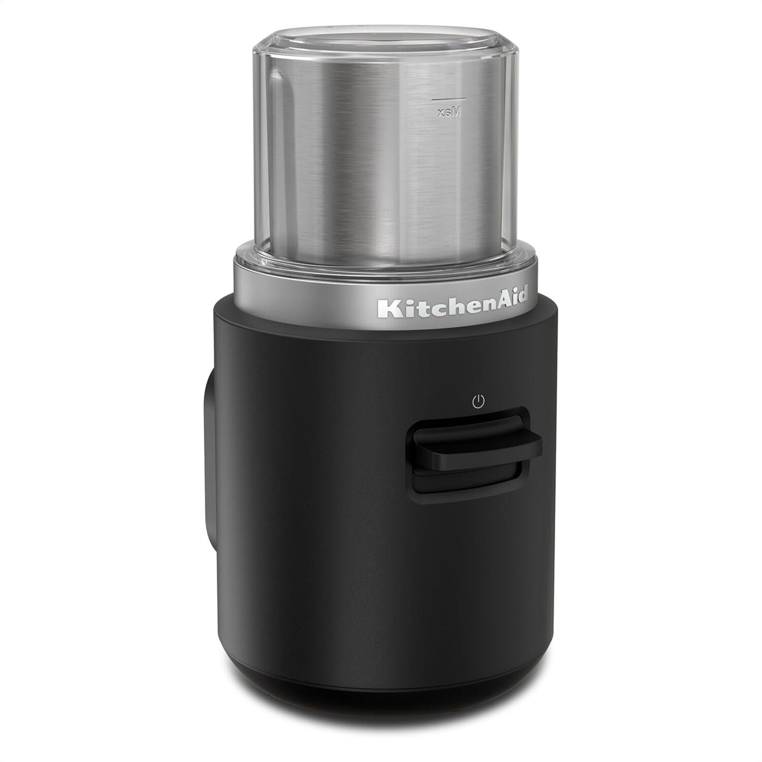 Black cordless coffee grinder with clear grinding chamber and stainless top; front button visible