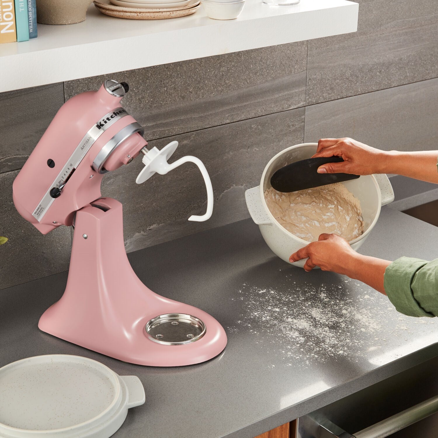 Matte dried rose stand mixer dispensing dough into a mixing bowl on the counter