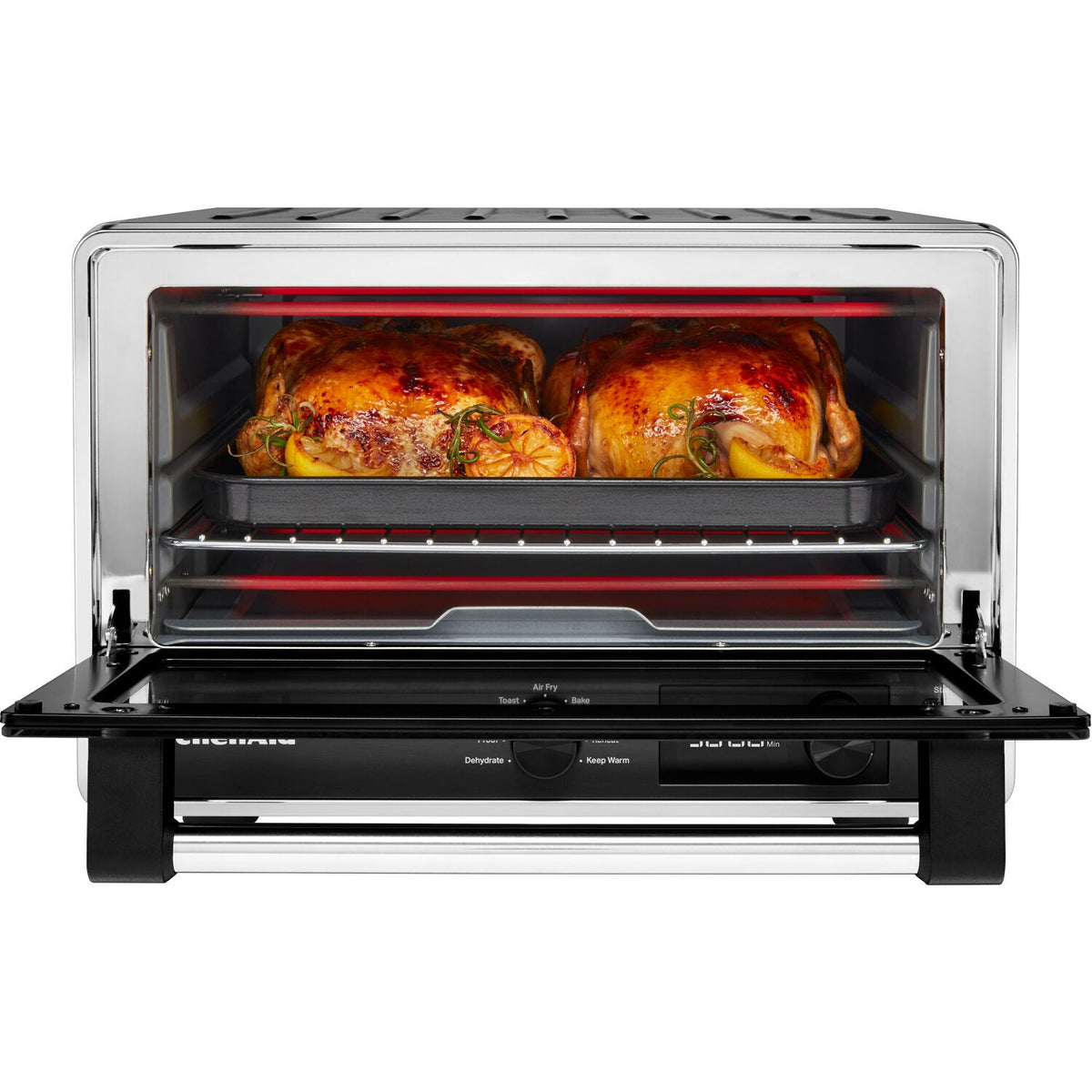 KitchenAid countertop air-fry oven with door open, roasting tray and cooked chicken inside