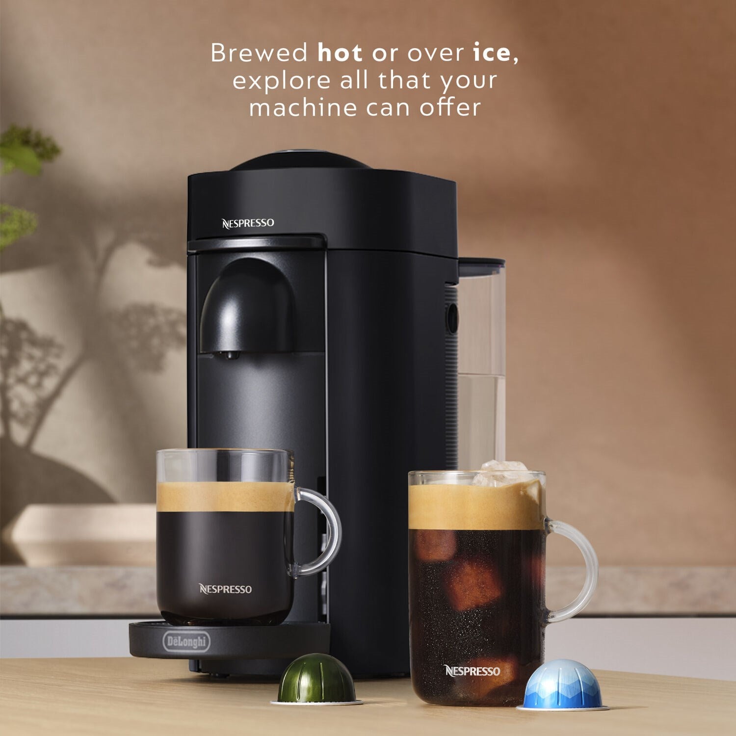 Black De'Longhi Nespresso Vertuo Plus machine beside cups and capsules