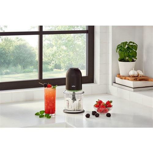 Black mini food chopper on counter with clear bowl and blade inside