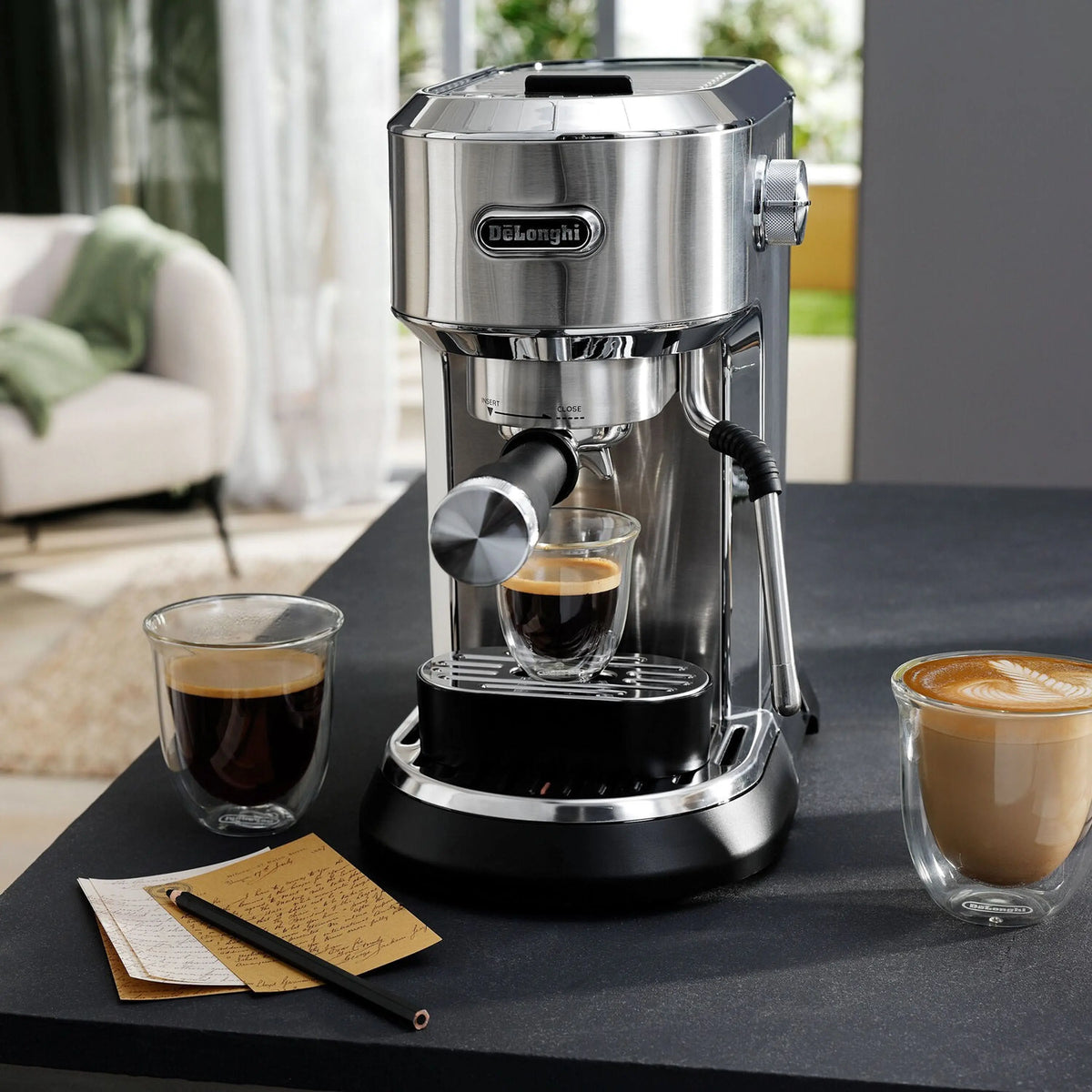 Stainless steel espresso machine dispensing espresso into a cup with multiple drinks nearby