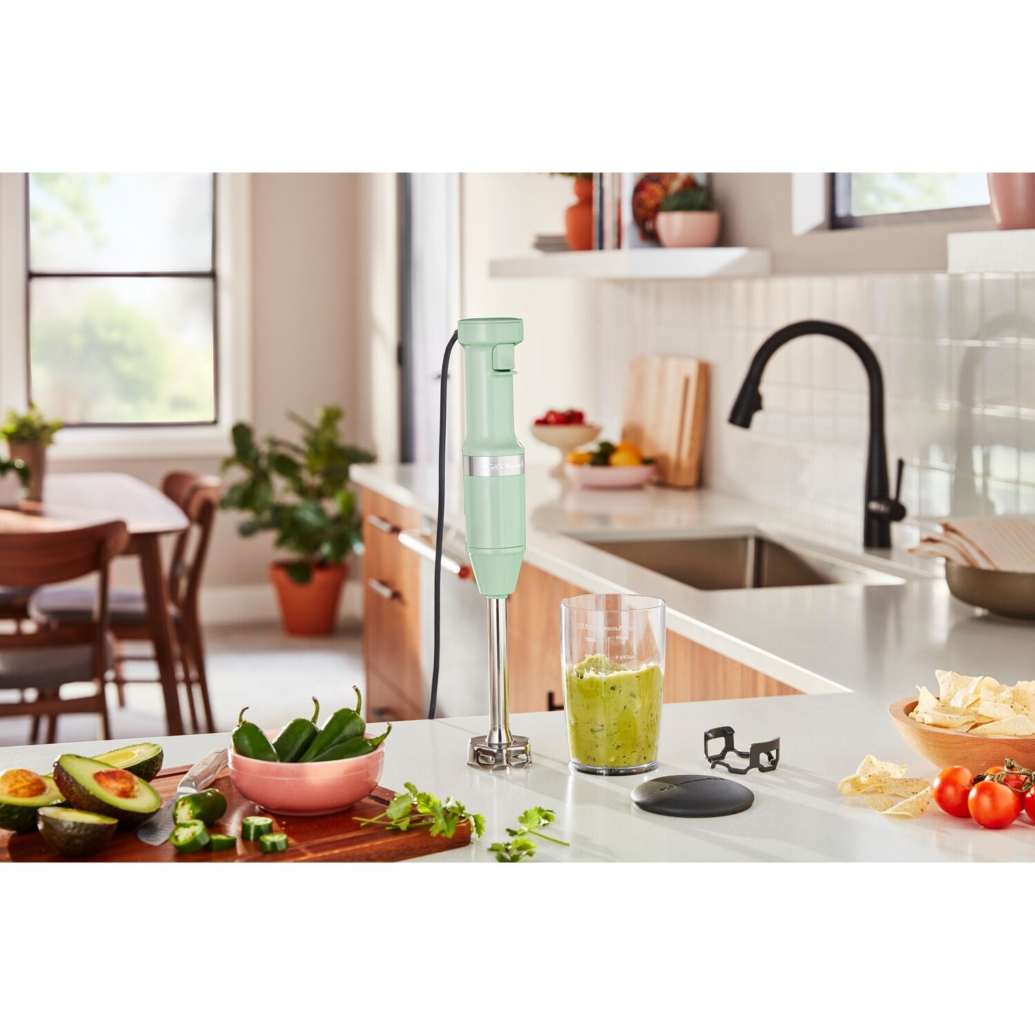 Pistachio immersion blender blending in jar on a kitchen counter
