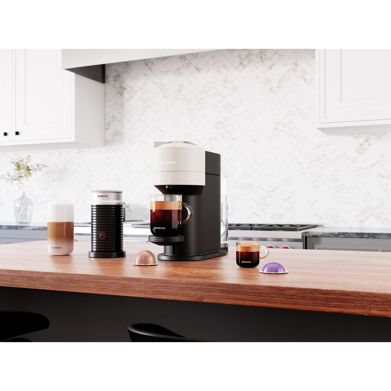 White Vertuo Next coffee machine with frother, cups, and capsule pods on countertop