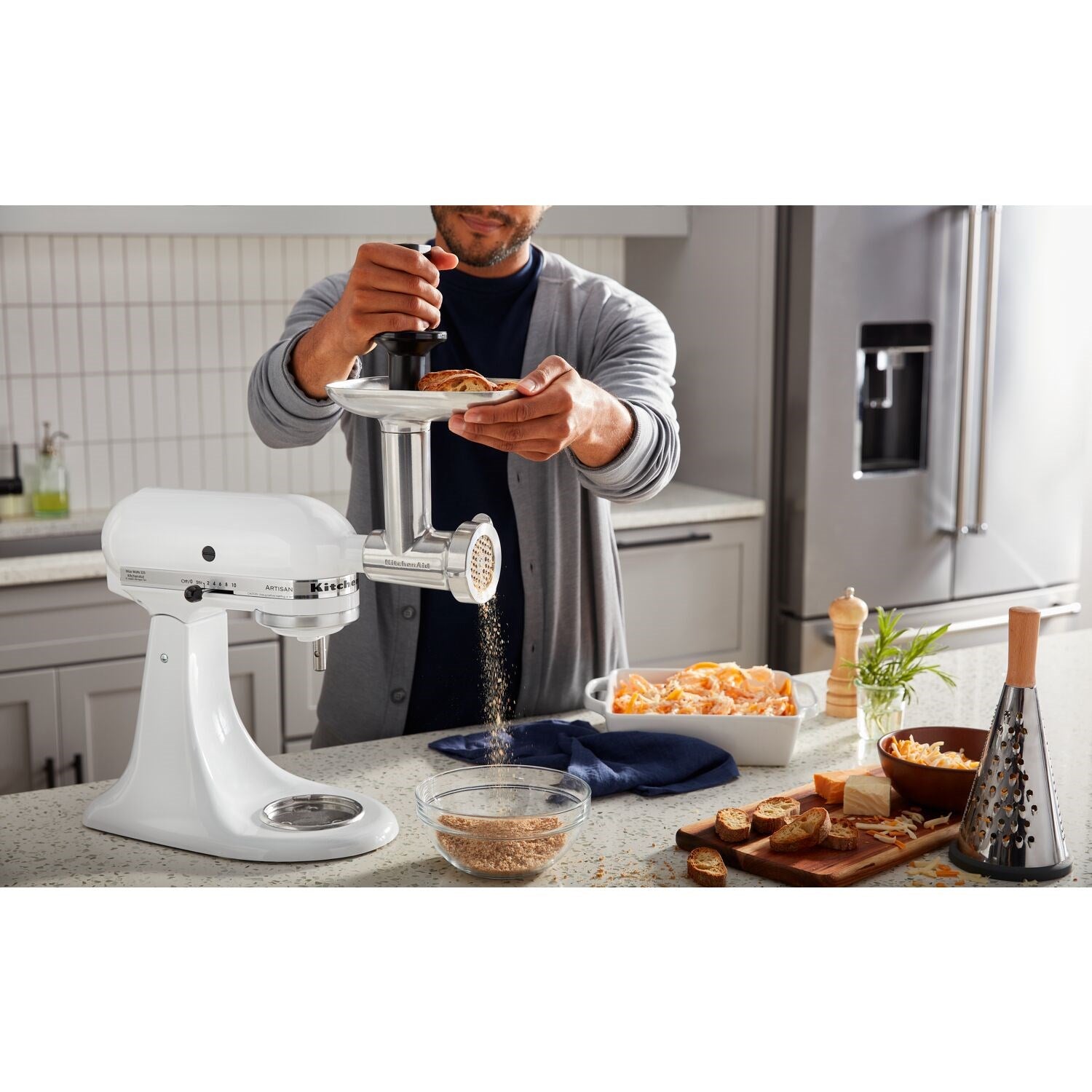 White tilt-head stand mixer with stainless bowl while pouring ingredients into it.