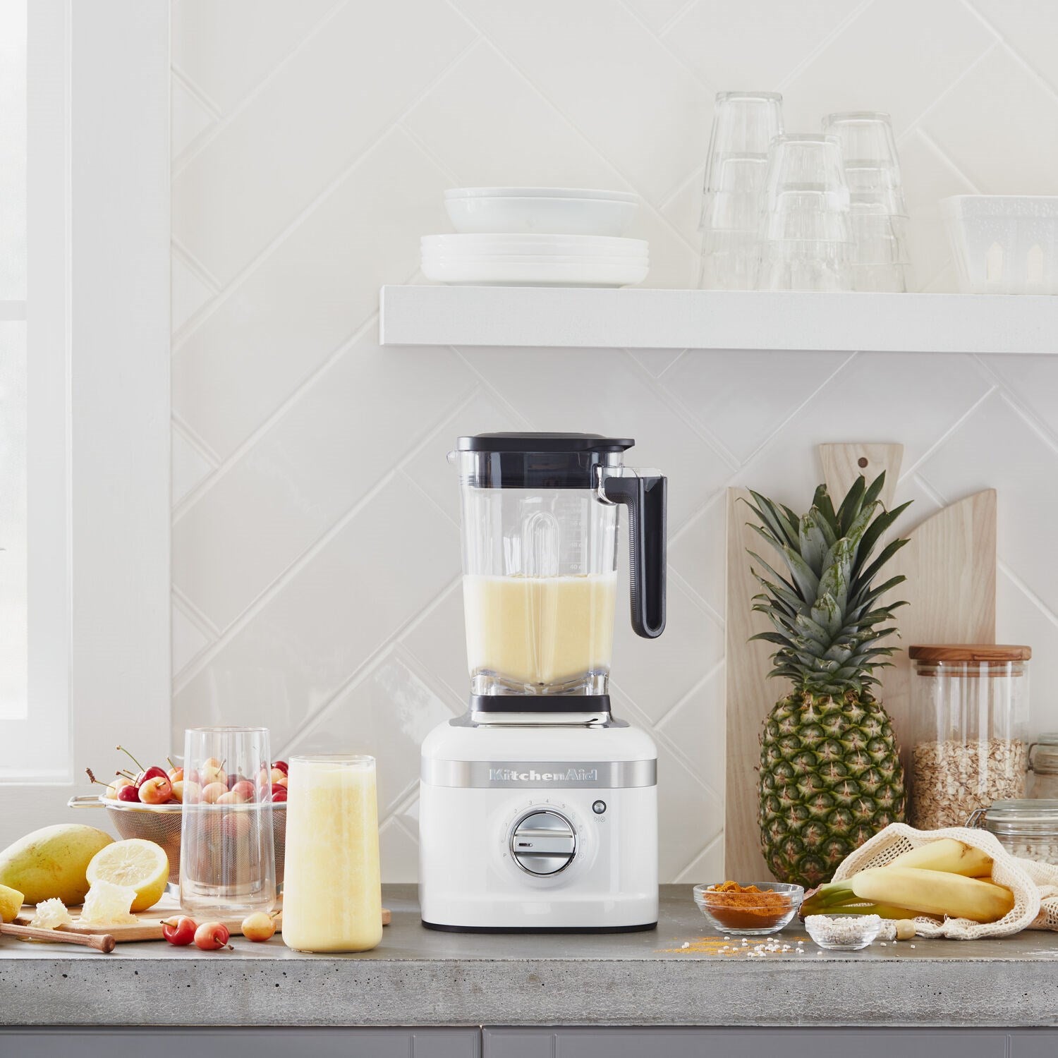 White blender with clear jar filled with pale yellow smoothie