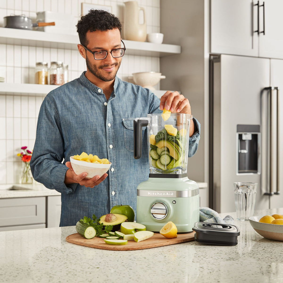 KitchenAid K400 blender on kitchen counter with sliced fruits and vegetables