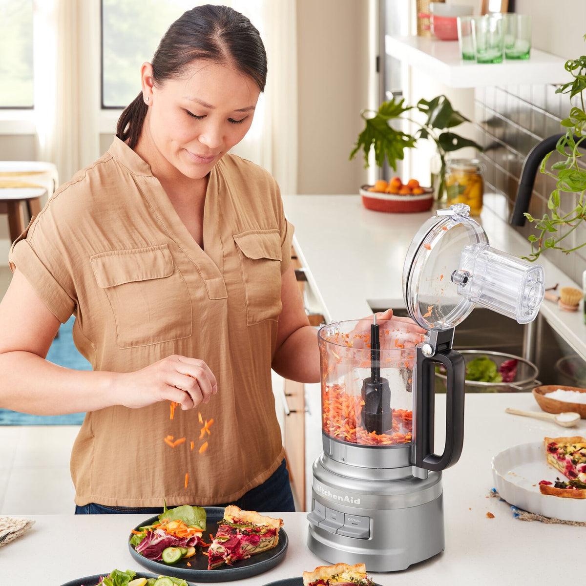 KitchenAid food processor on counter beside prepared ingredients
