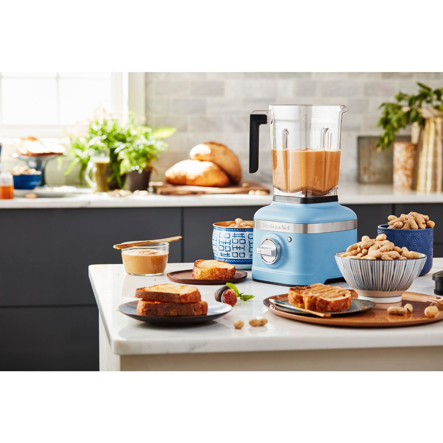 KitchenAid K400 blender on kitchen counter with blended drink and snack plates