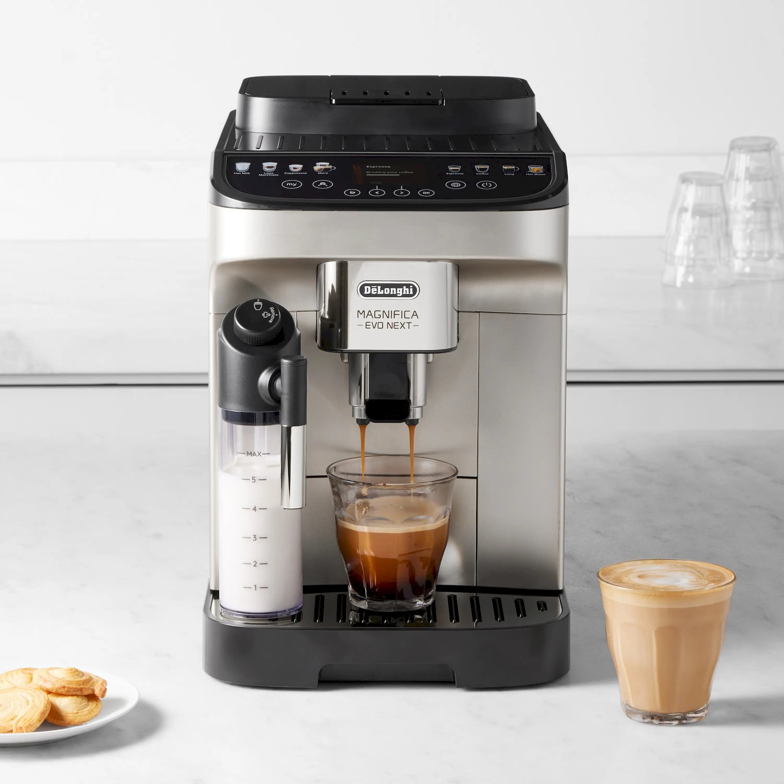 Fully automatic espresso machine dispensing coffee into a clear cup, stainless and black.