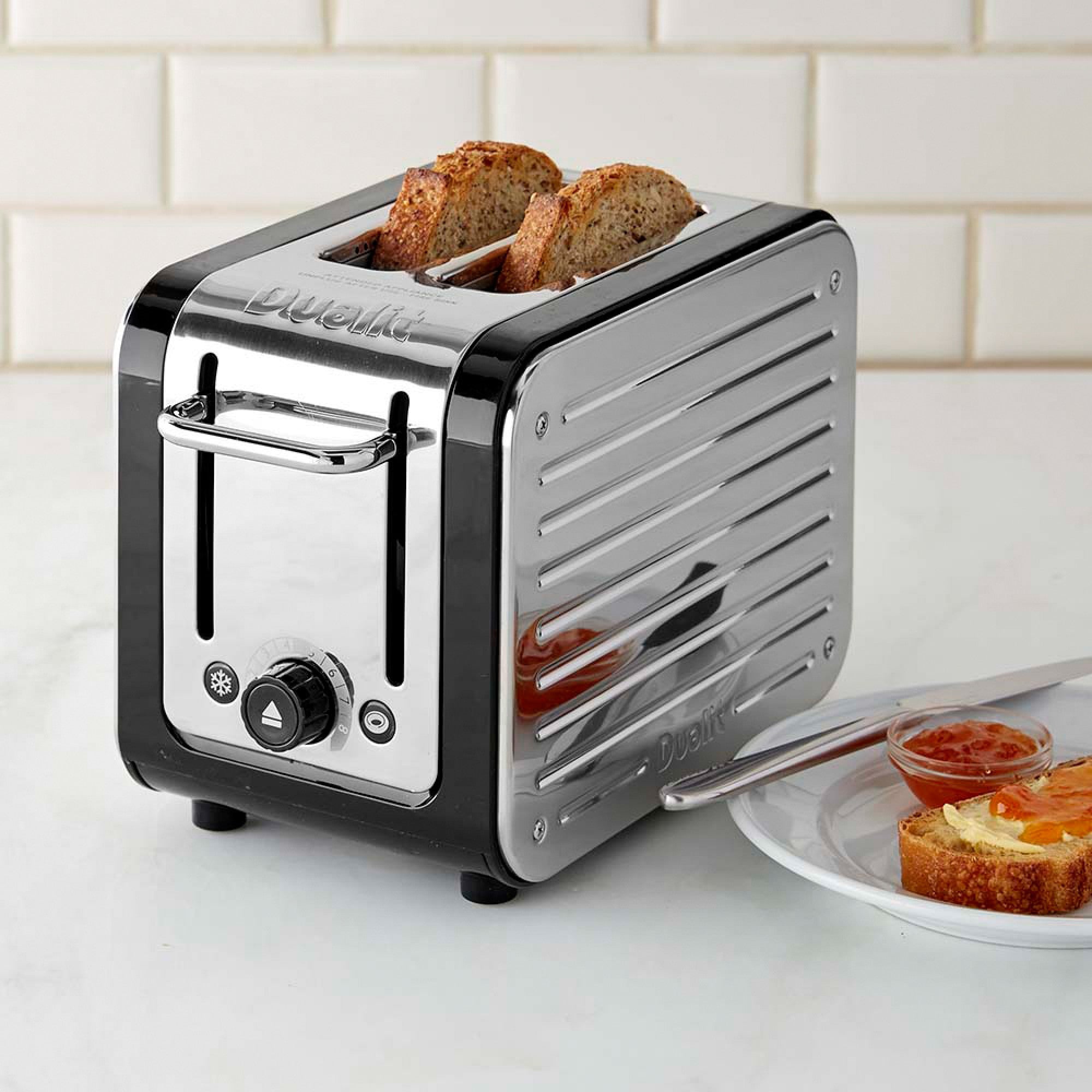 Dualit 2-slice toaster in chrome and black with two bread slices in slots