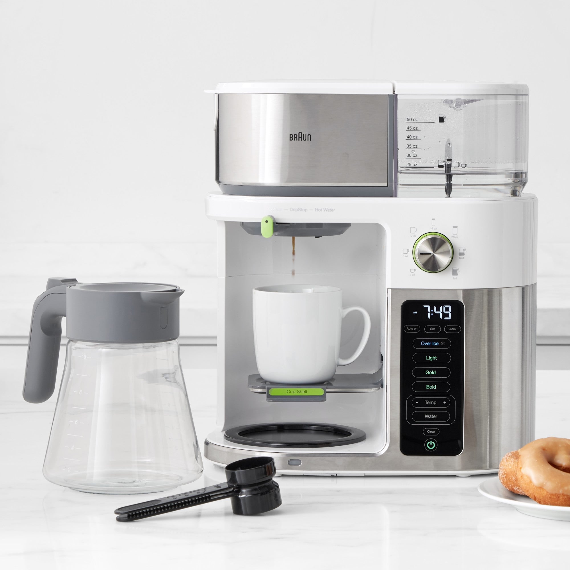 Stainless steel and white coffee machine with glass carafe, mug, and drip spout