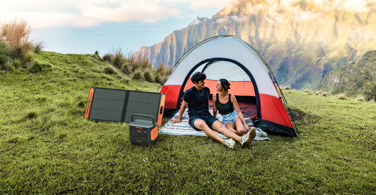Jackery solar generator beside camping tent for portable off-grid charging
