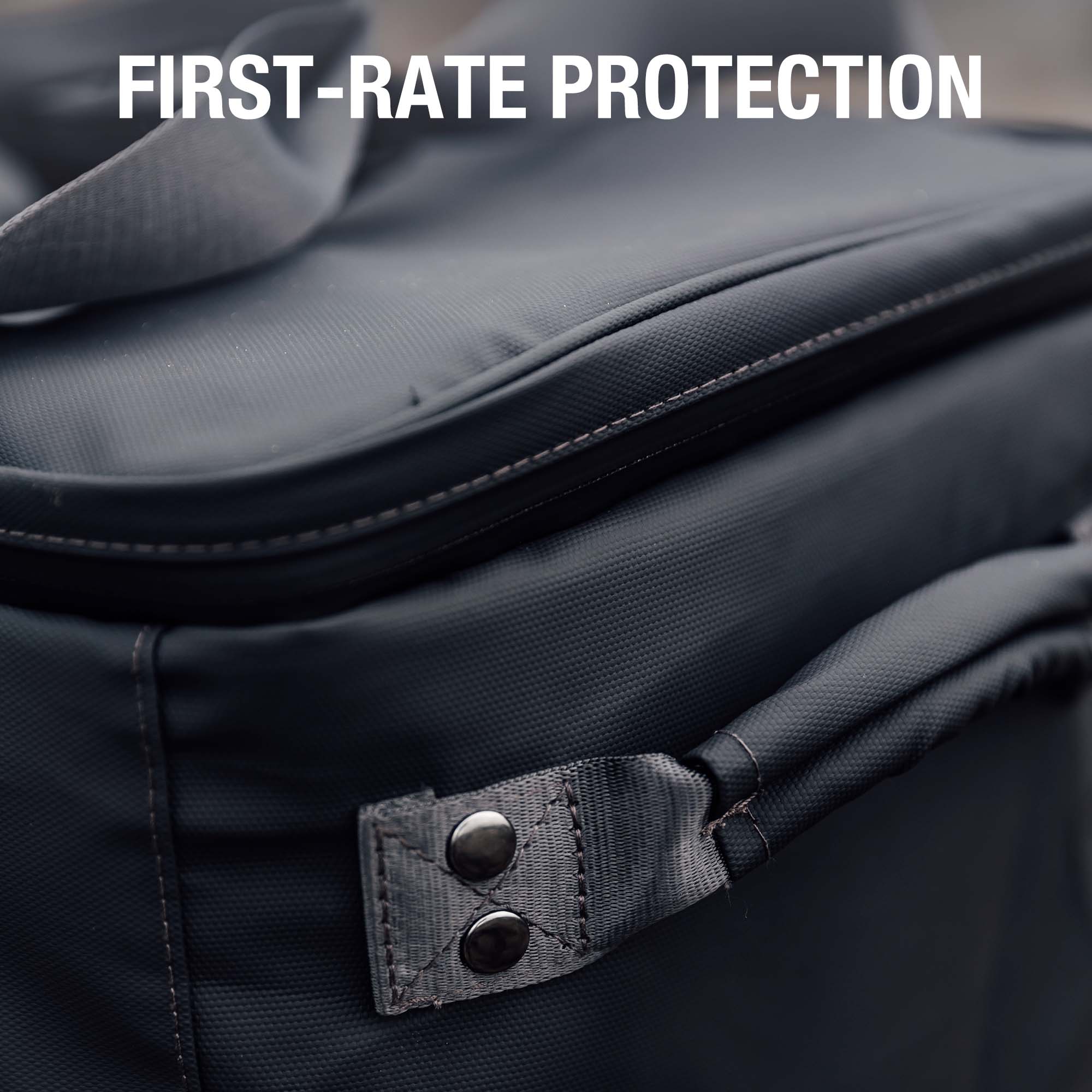 Dark carrying case close-up with padded lining, stitched edges, and snap strap tab