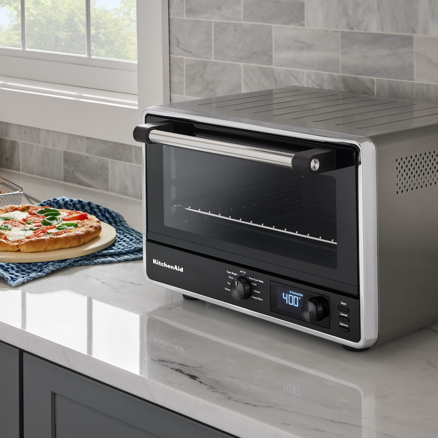 KitchenAid countertop oven on kitchen counter with glass door and digital controls, Contour Silver