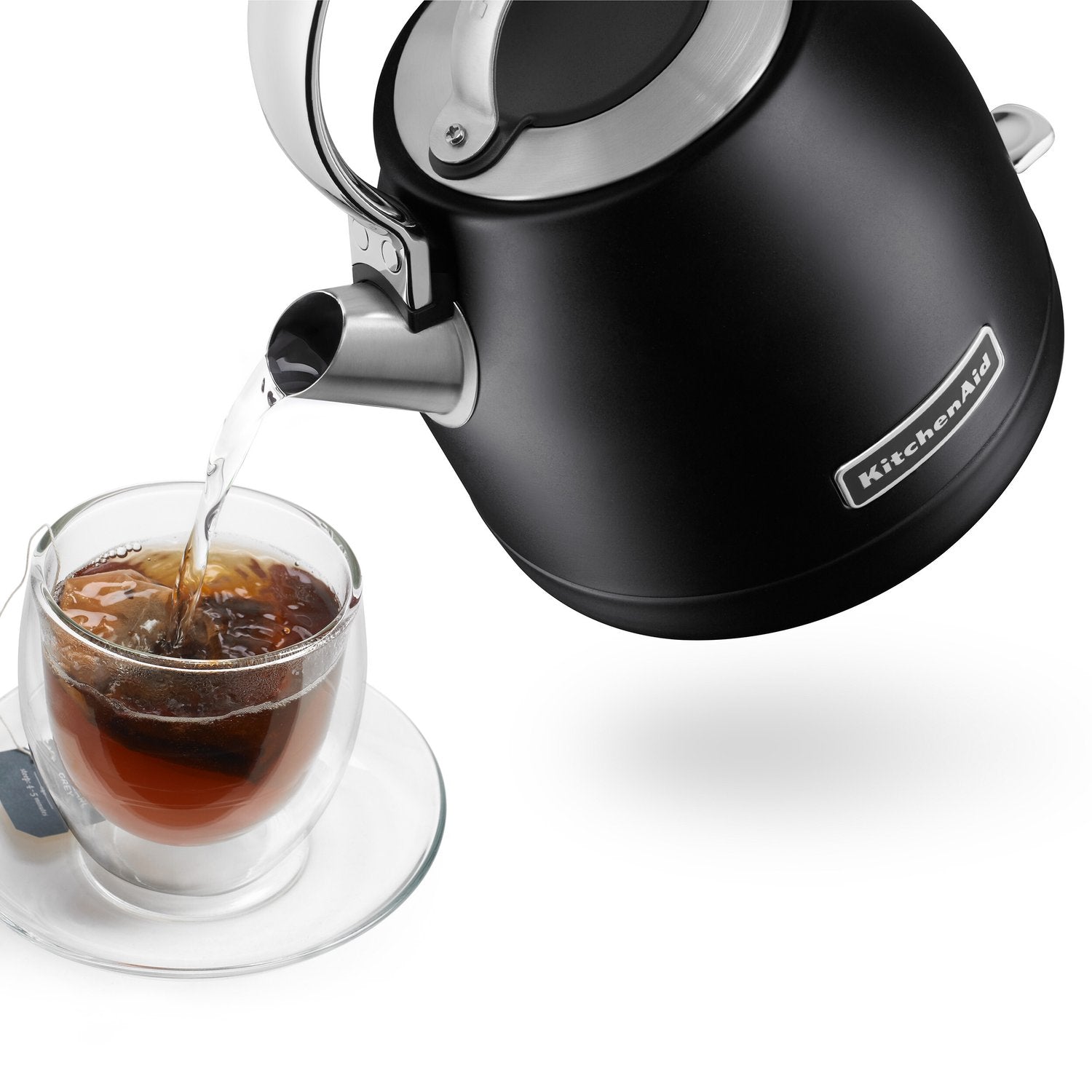 Black electric kettle with pouring spout, stainless accents, tea cup beside it