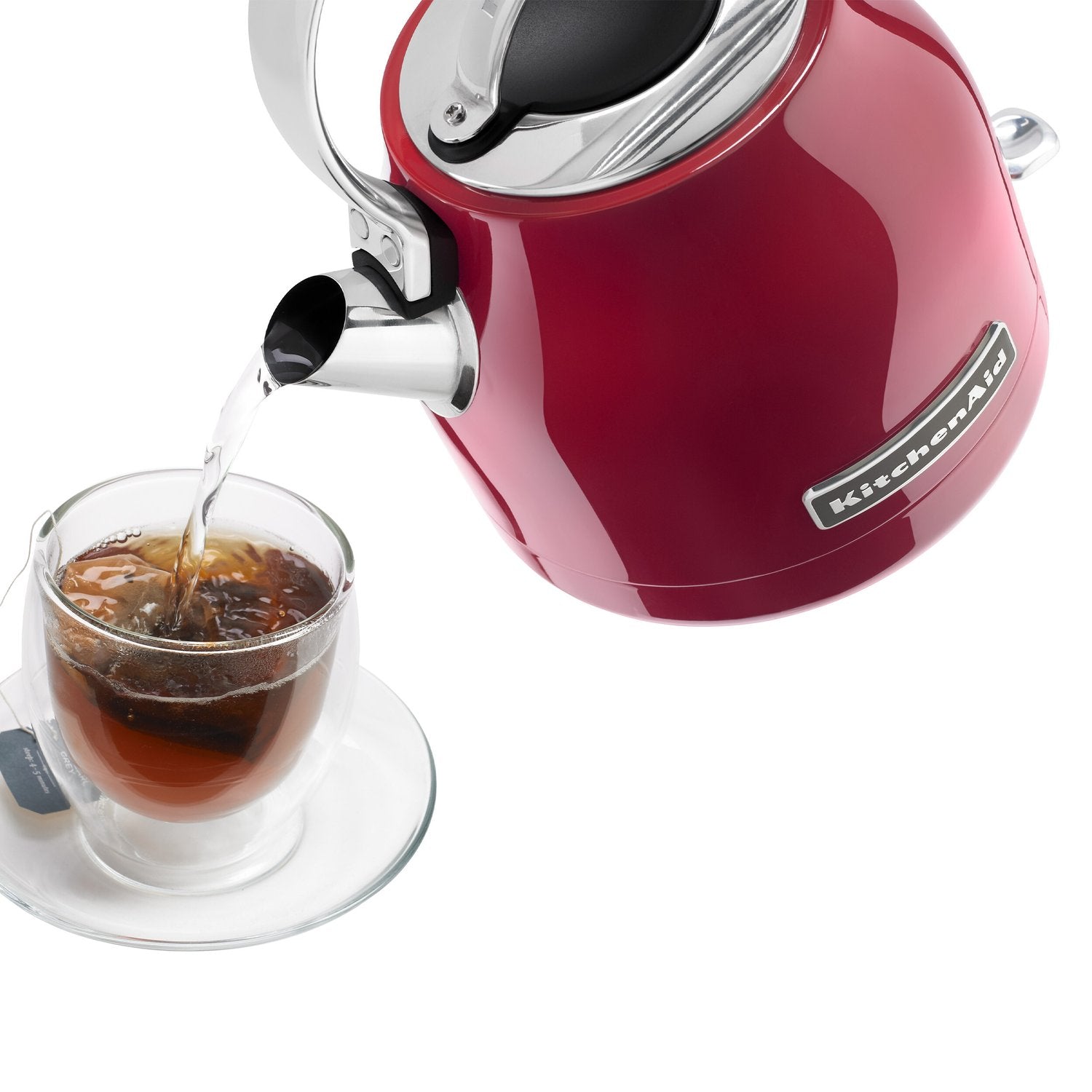 Electric water kettle pouring into a glass cup of tea