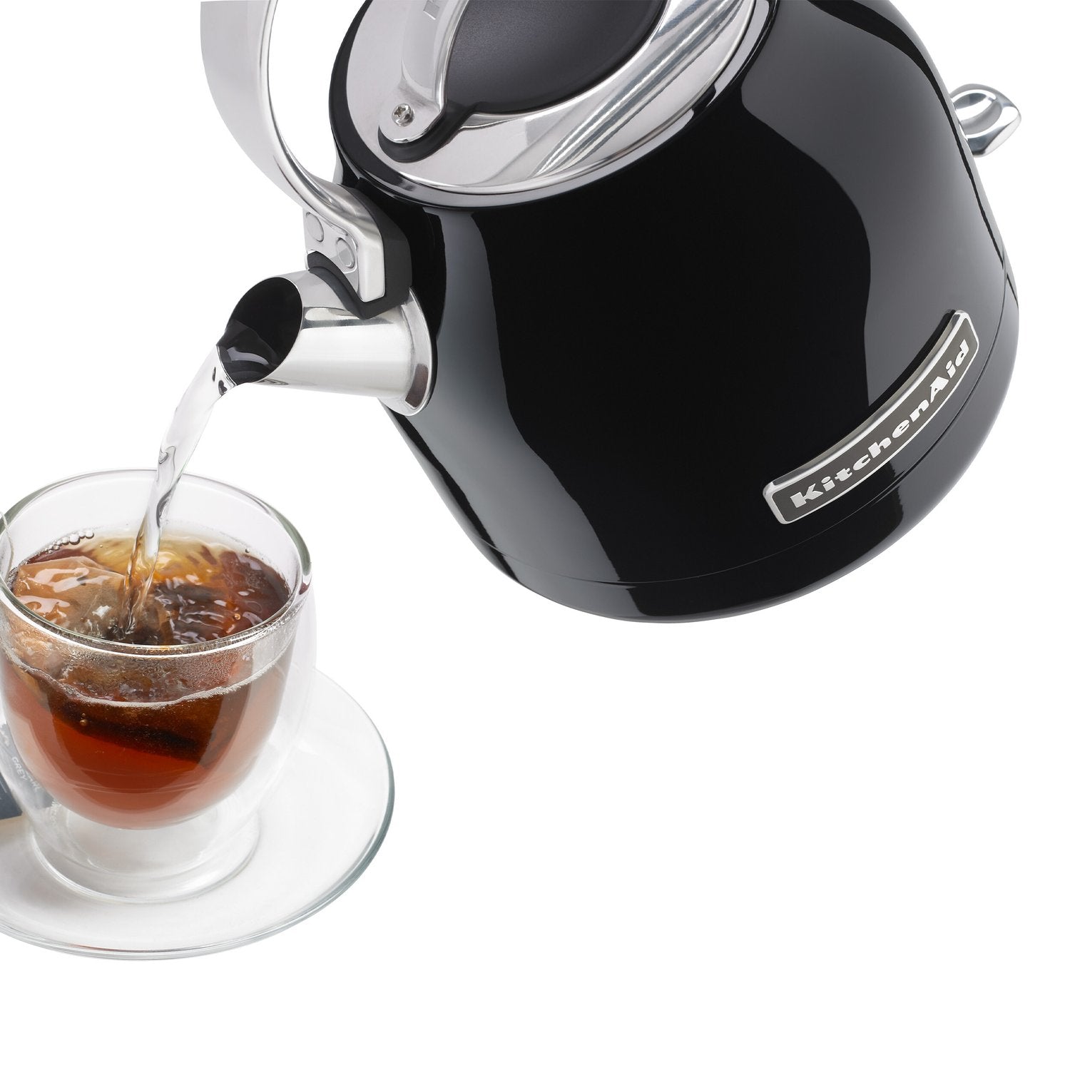Onyx black electric water kettle pouring hot water into a clear cup