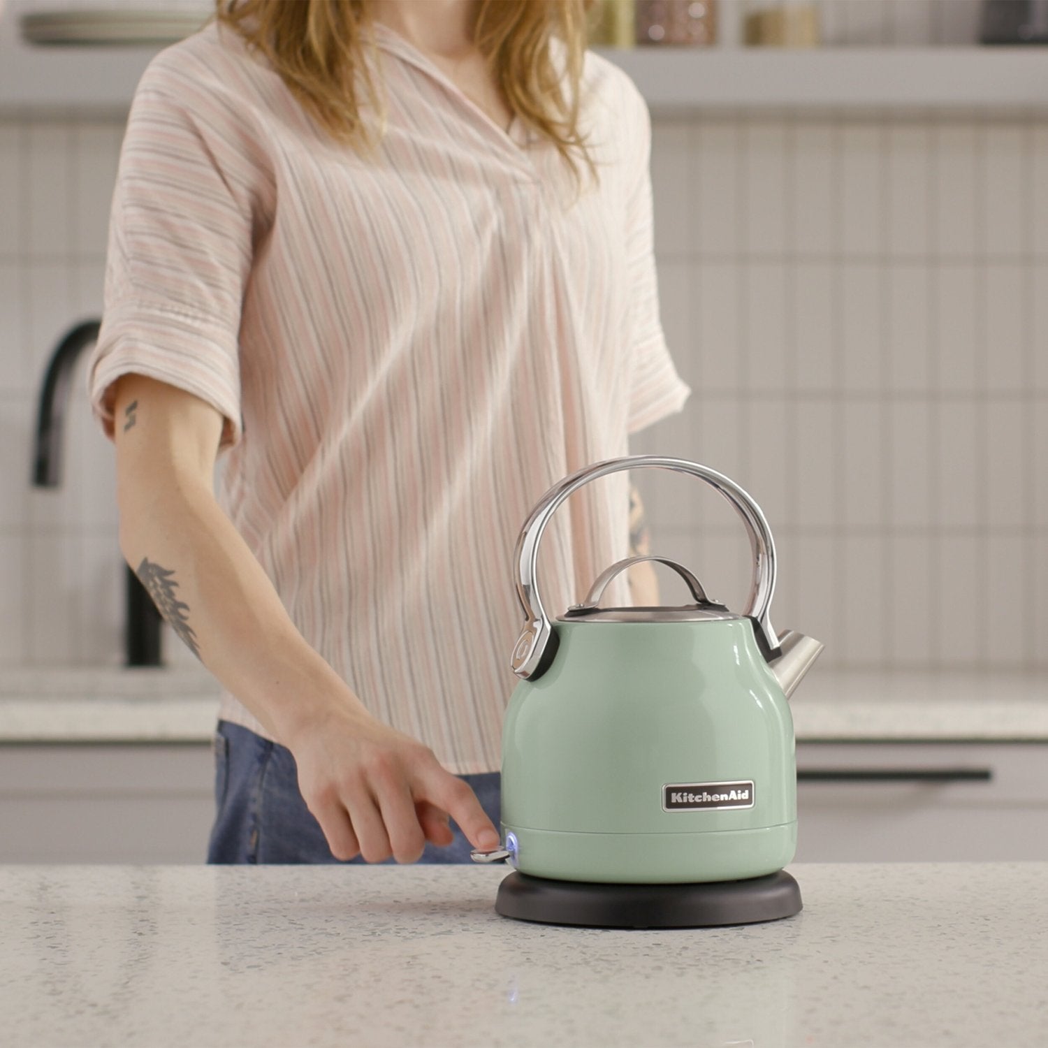 Pistacchio KitchenAid electric water kettle with spout on countertop, being filled