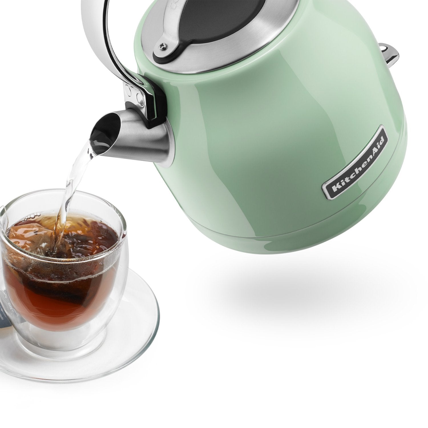 Pistacchio KitchenAid electric kettle pouring hot water into glass cup on saucer