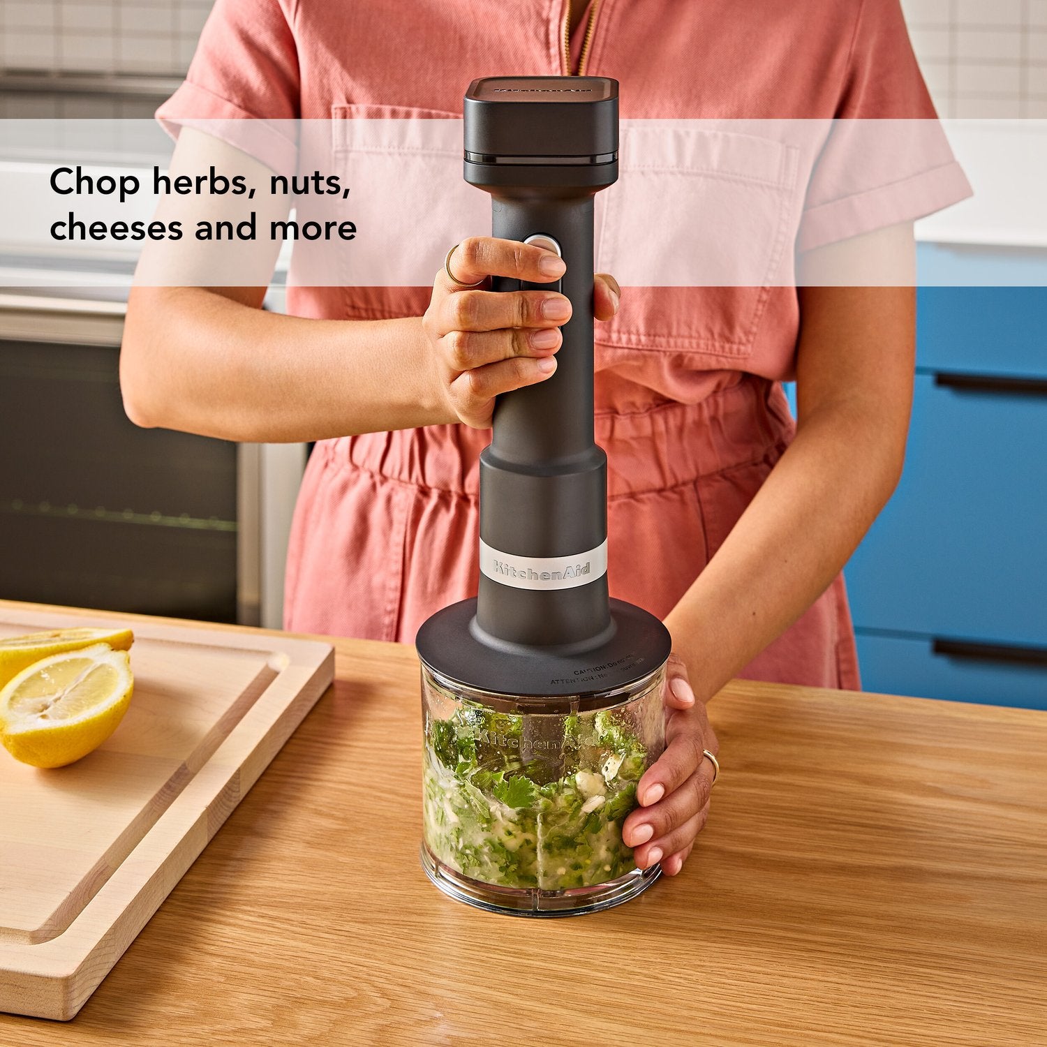 Black matte cordless hand blender in glass chopper cup, handheld blending.