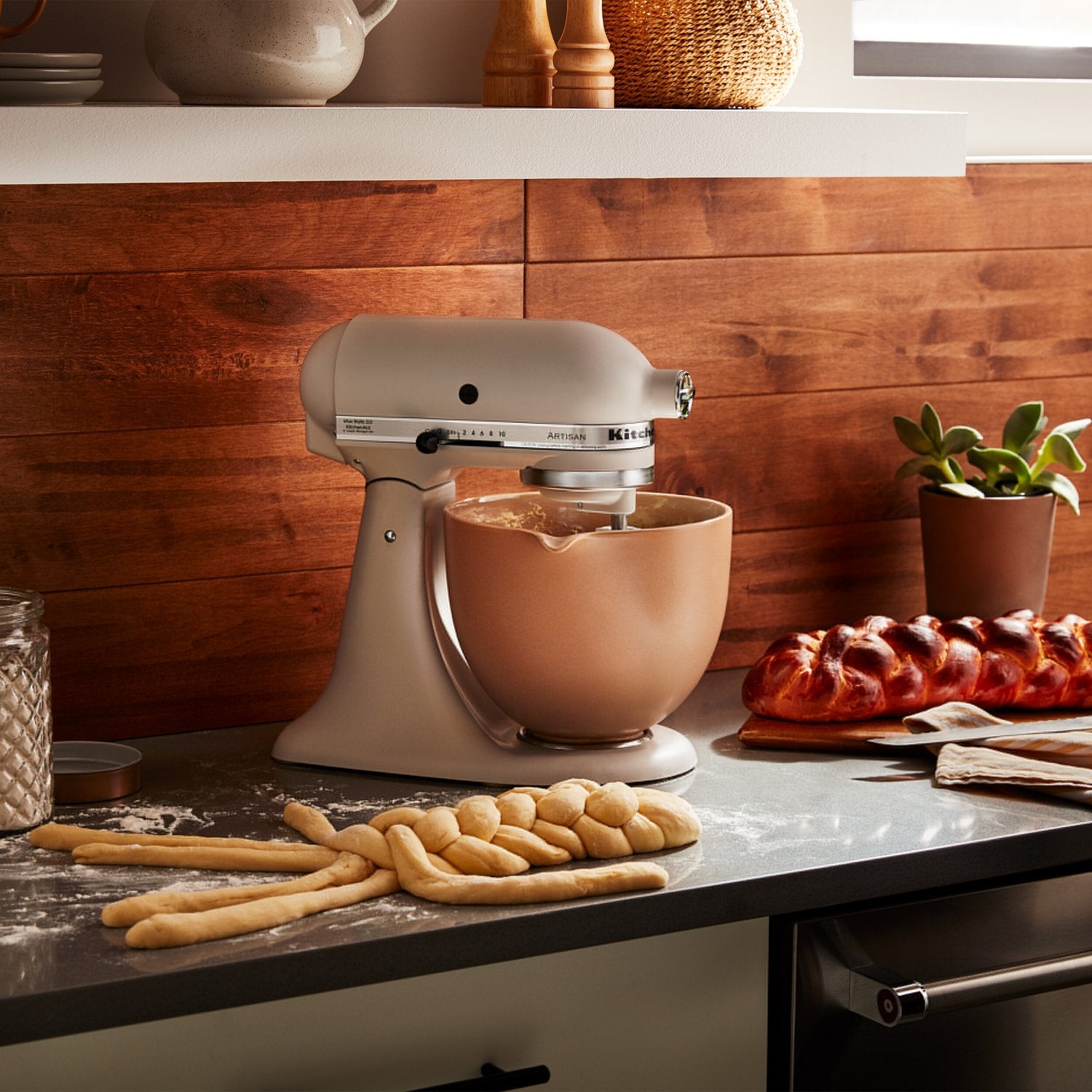 Ceramic mixing bowl attached to stand mixer, fired clay tan with rounded sides