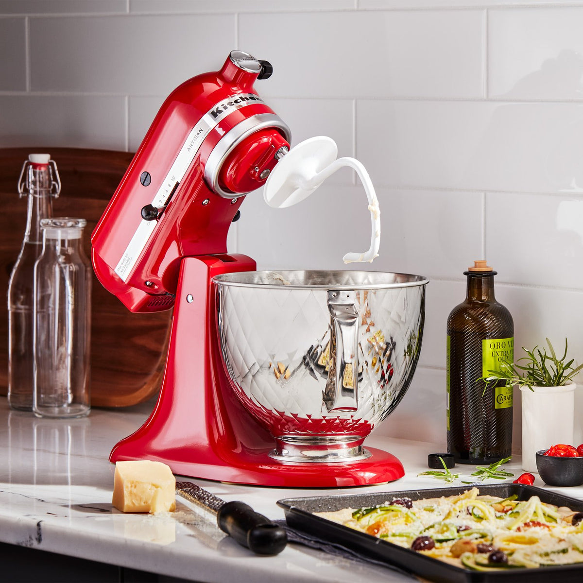 Stainless steel stand mixer bowl with quilted texture and side handle, shiny rim