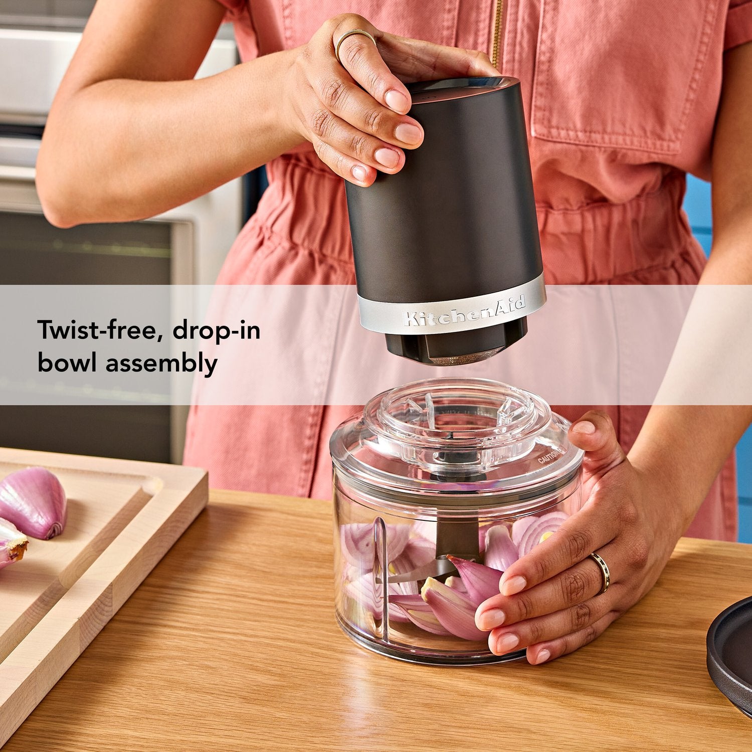 Black chopper drop-in bowl assembly with motor top fitted over a clear bowl