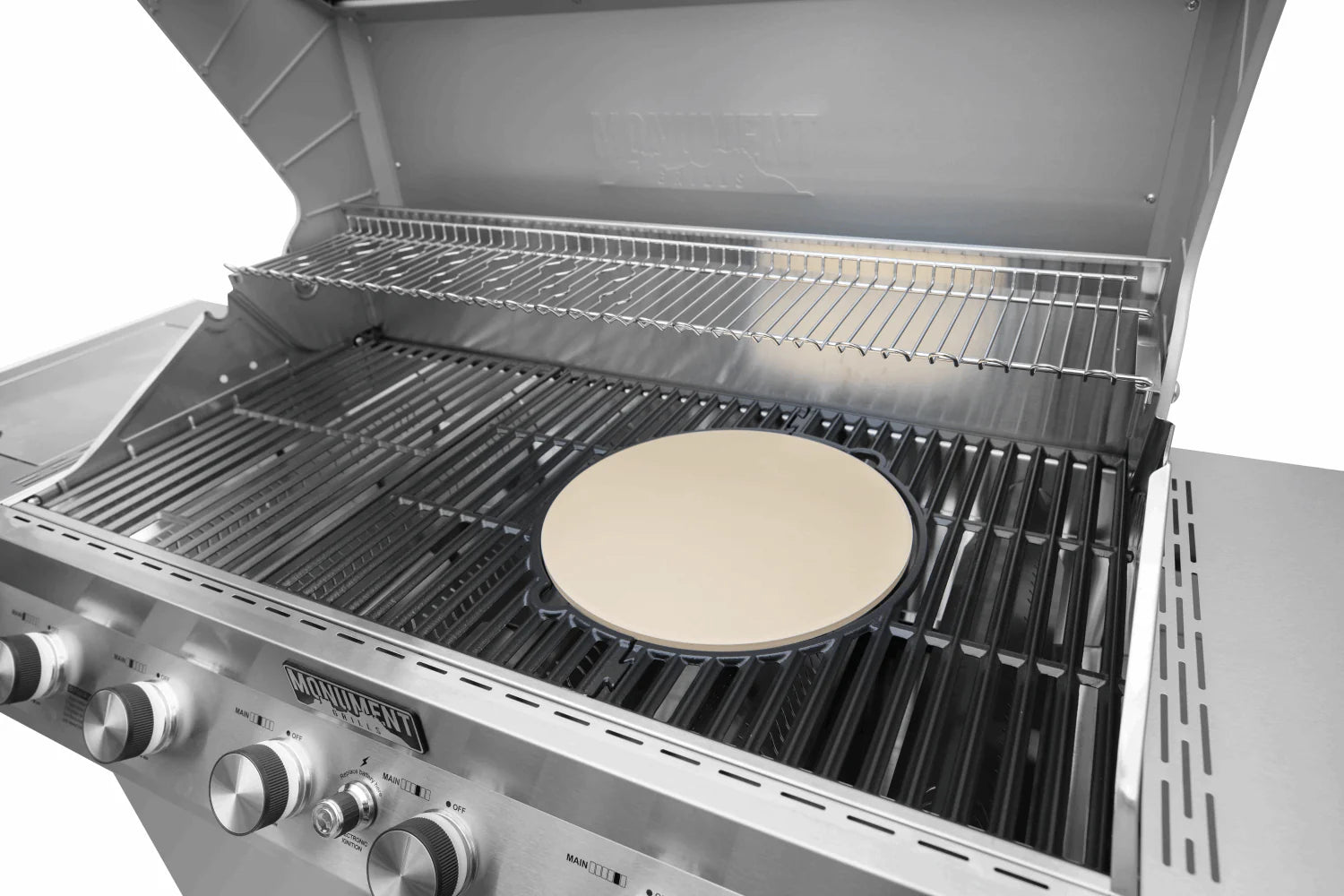 Round cordierite pizza stone on grill grates, pale tan circular disc