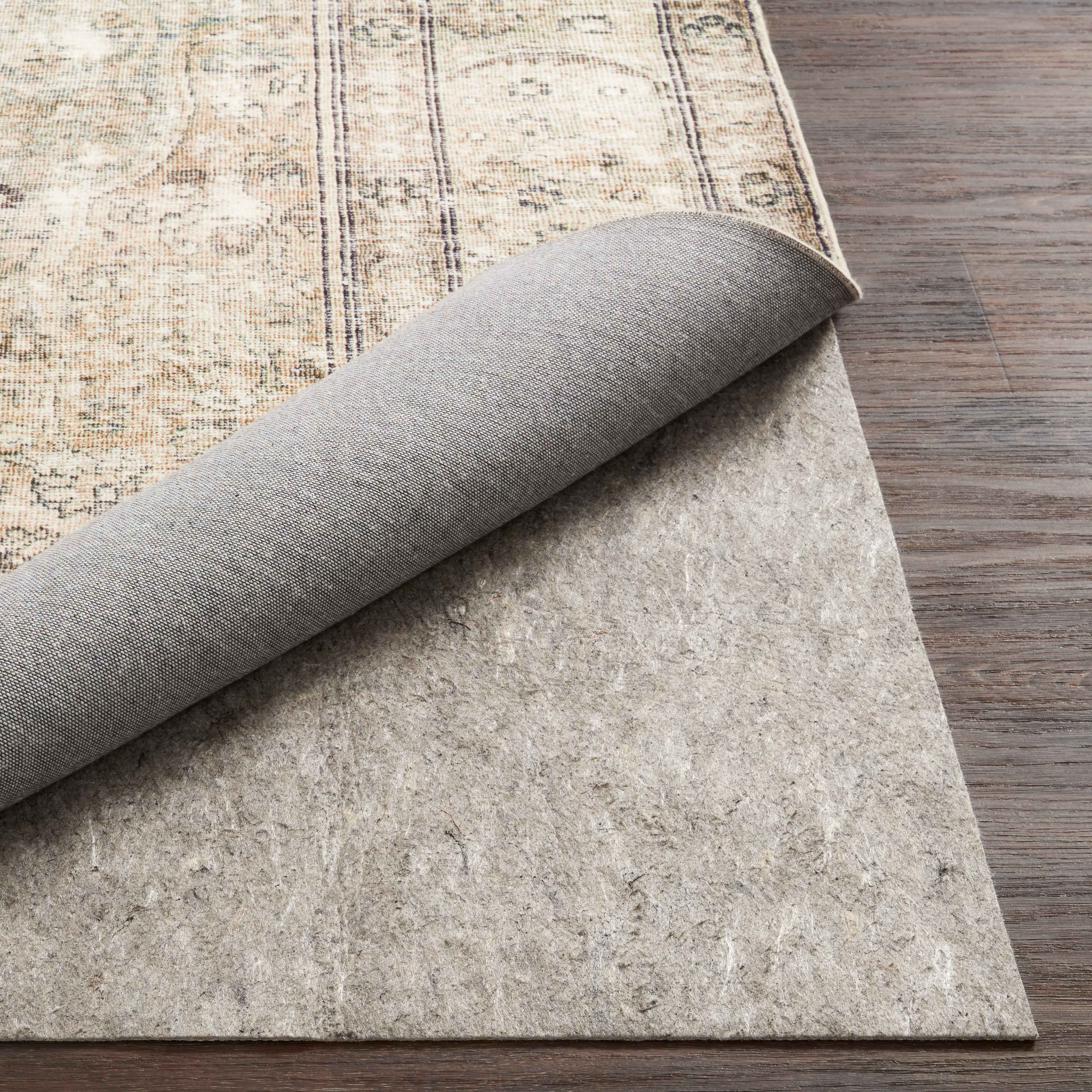 Grey textured rug pad with rolled edge, showing cushioning and grip underside
