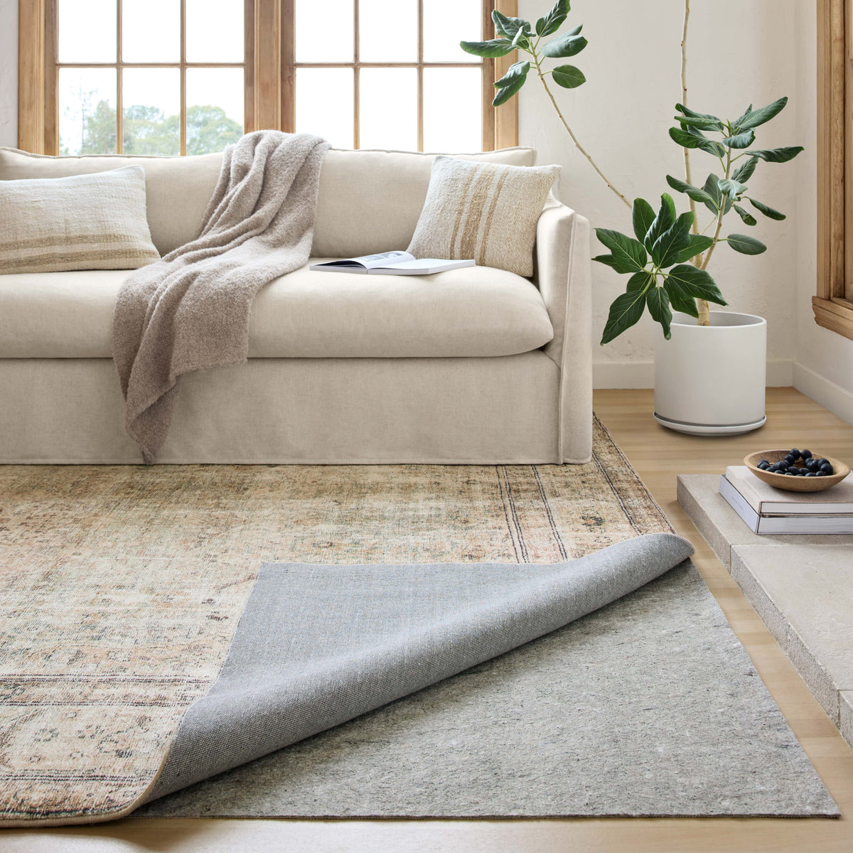 Grey rug grip pad laid under area rug in living room