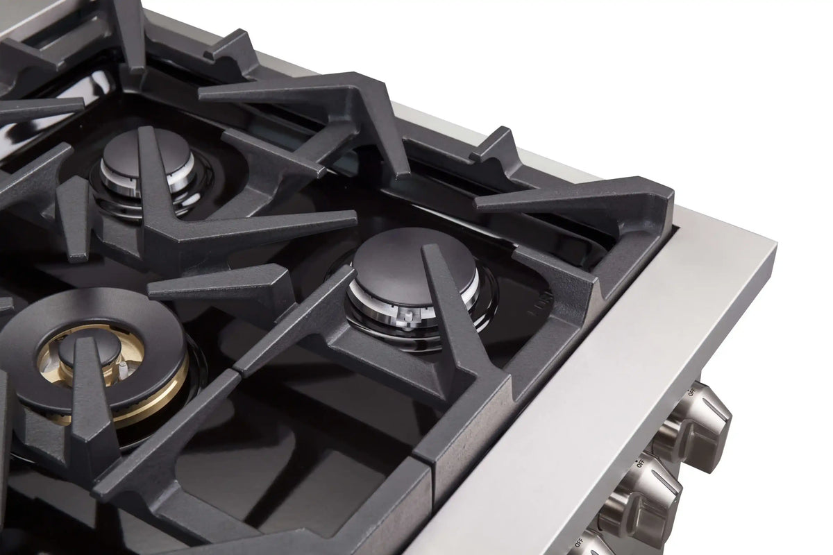 Stainless steel gas range cooktop with black grates and control knobs along the side