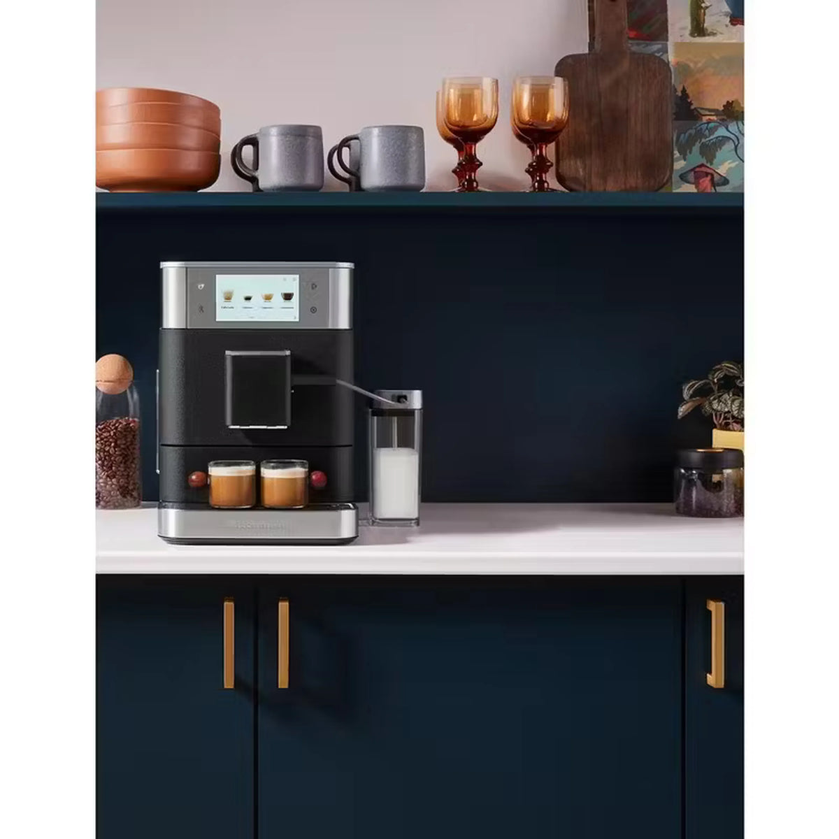 Black fully automatic espresso machine on countertop with milk container and spout
